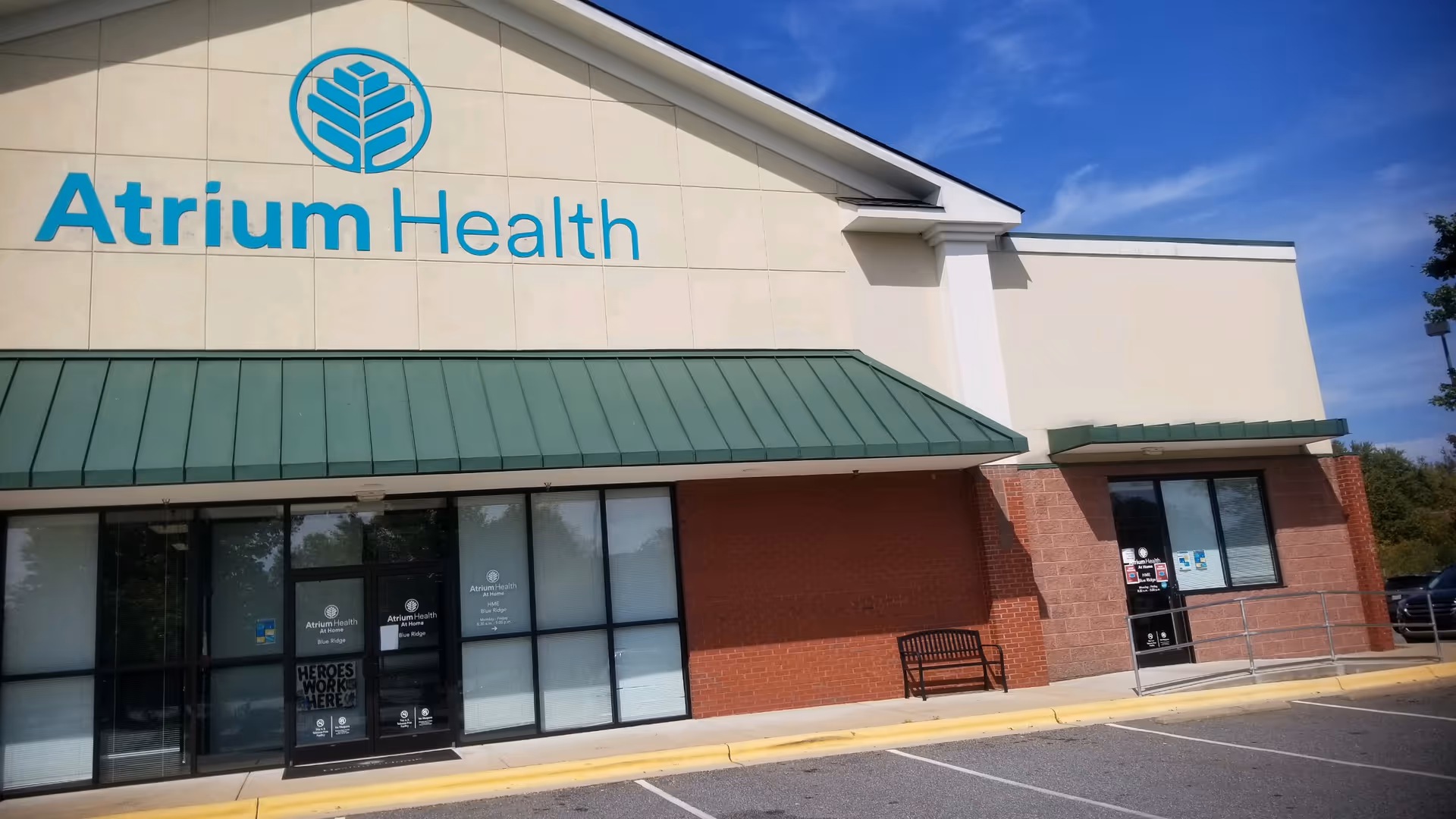 Exterior view of Atrium Health At Home building with blue logo and green awning.