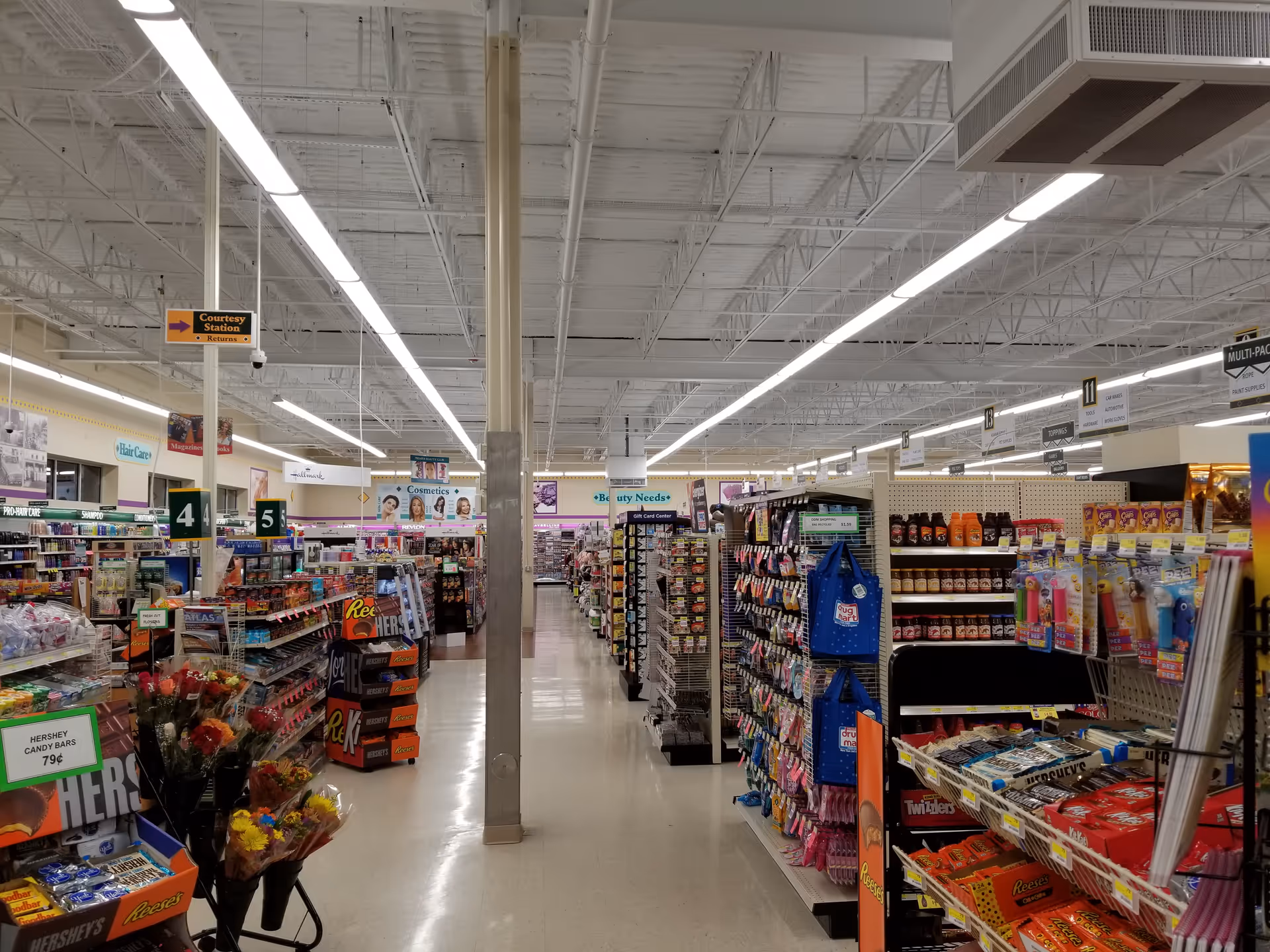 Inside Discount Drug Mart, a bright, busy store with long aisles and shelves.