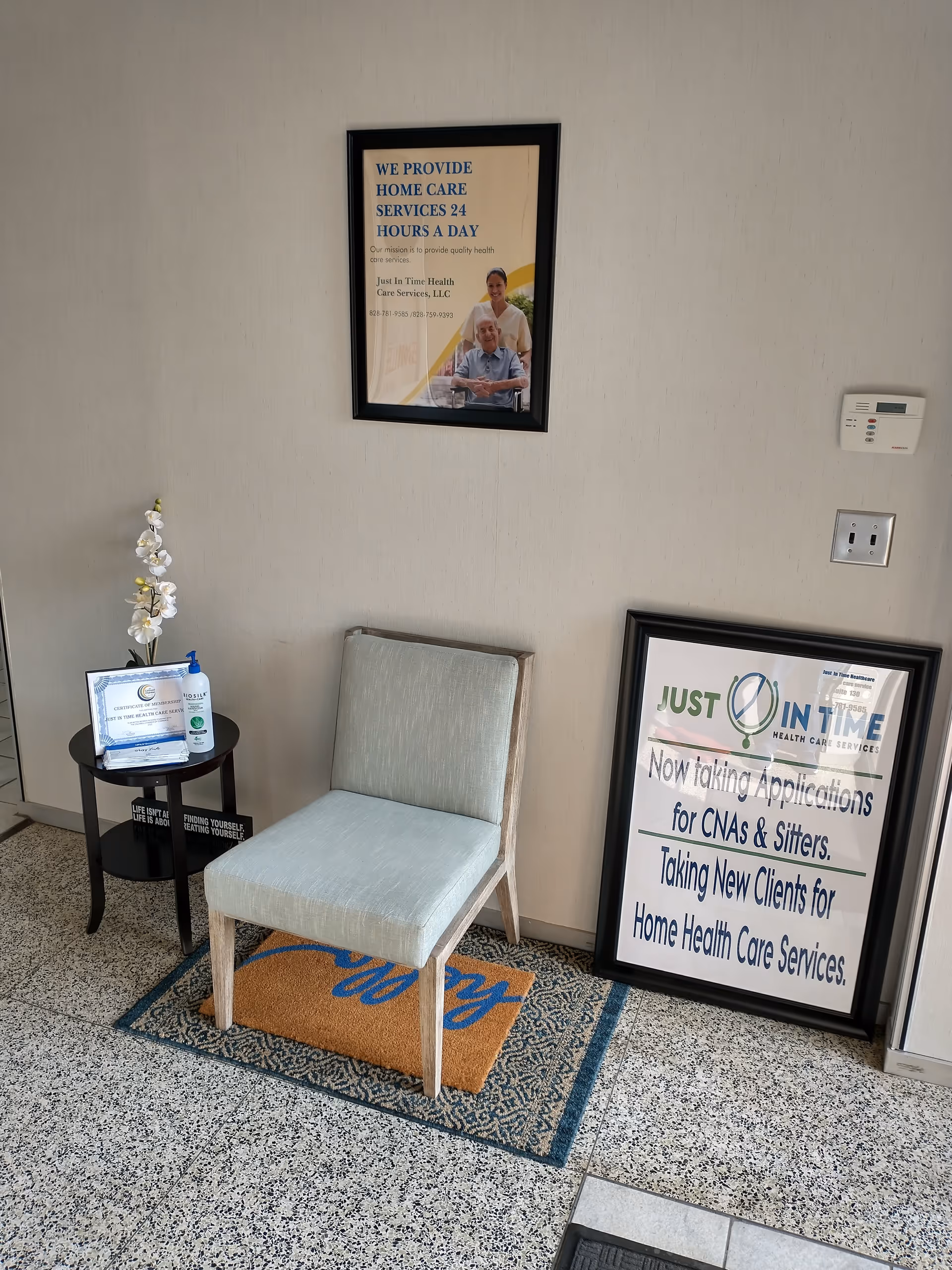 Senior care facility lobby with a chair, posters, and a small side table.