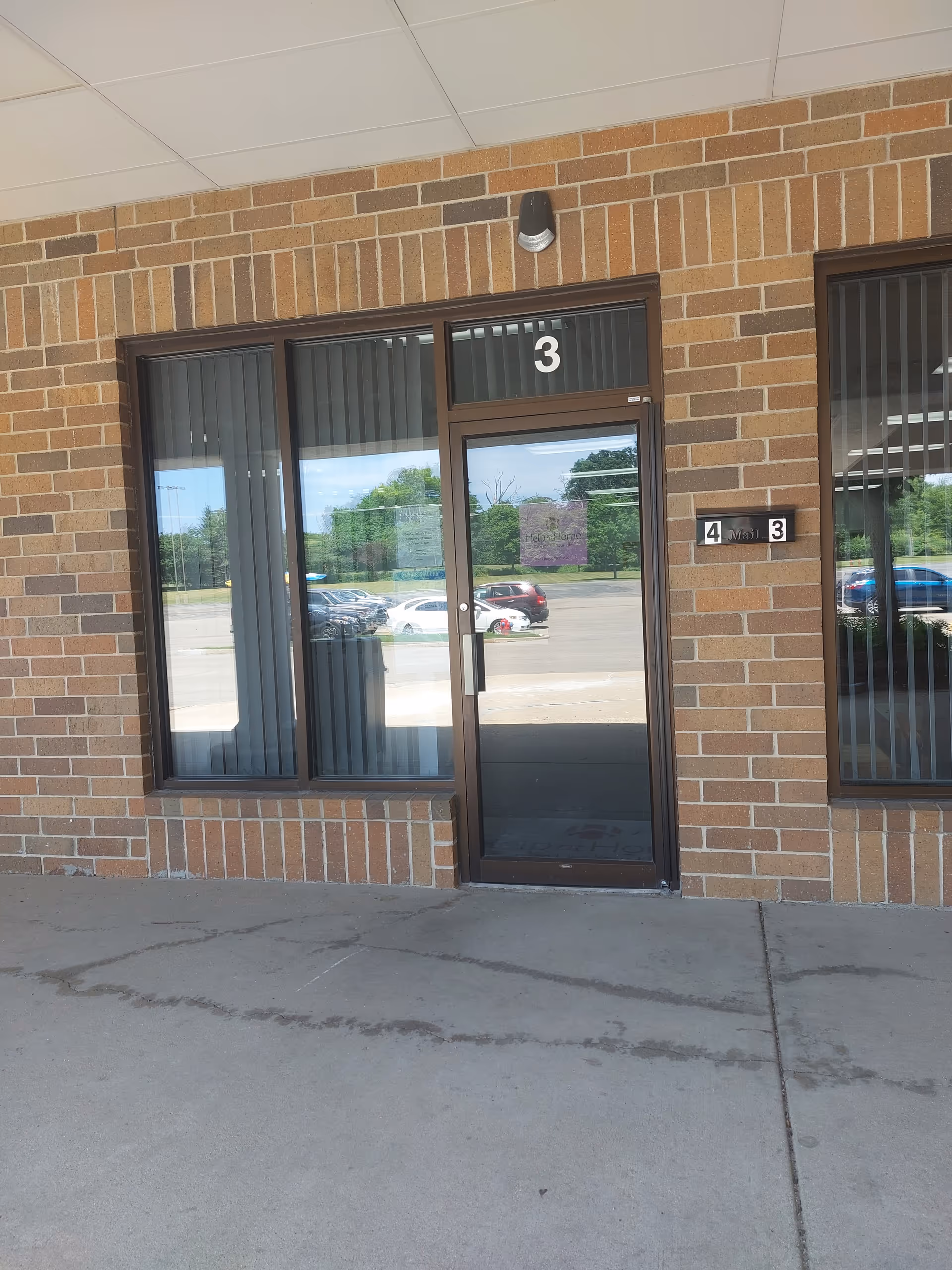 Brick exterior with glass entry door labeled 3 beside window panels.
