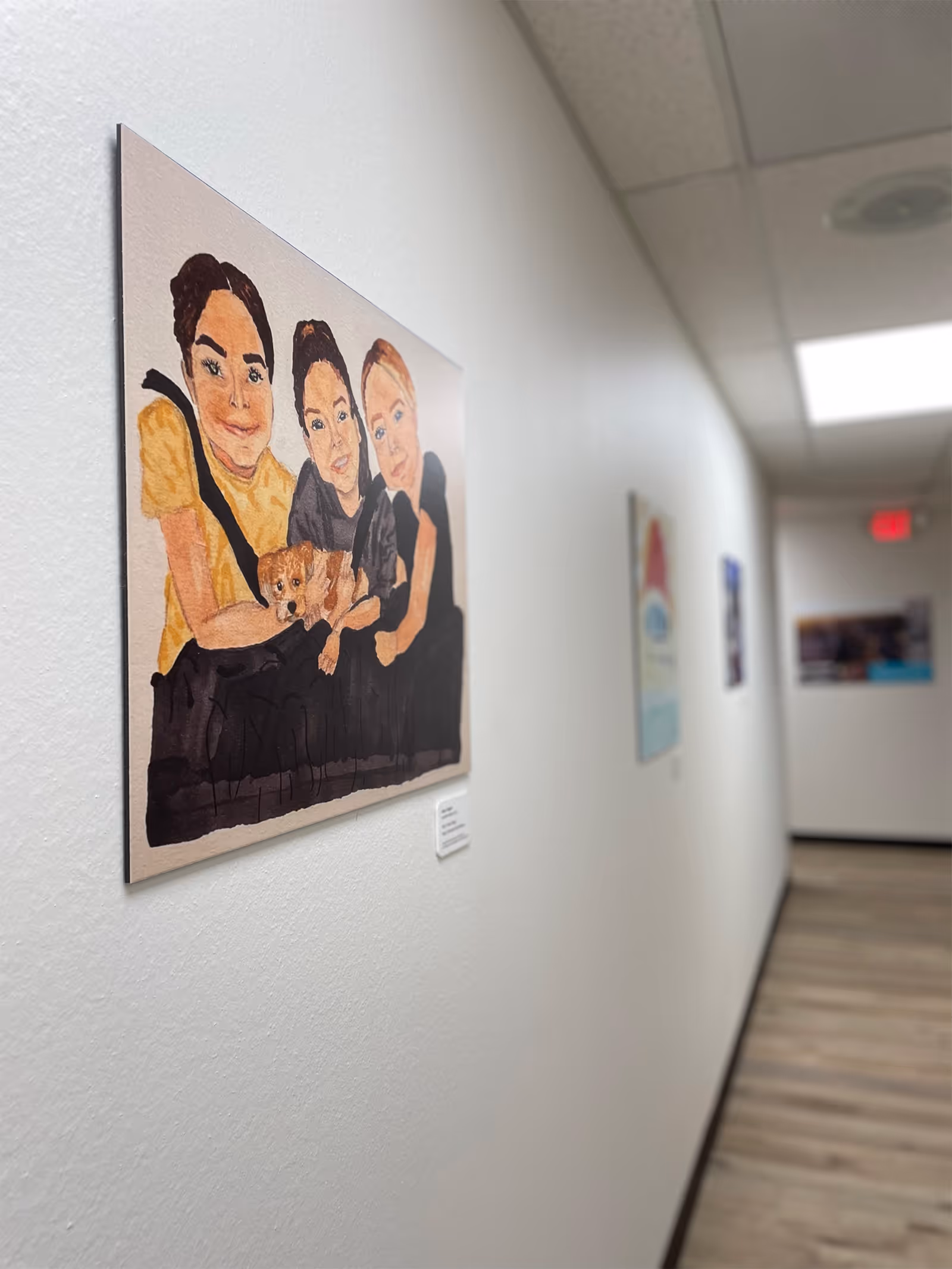 Hallway of a senior living facility with a large painting of a family.