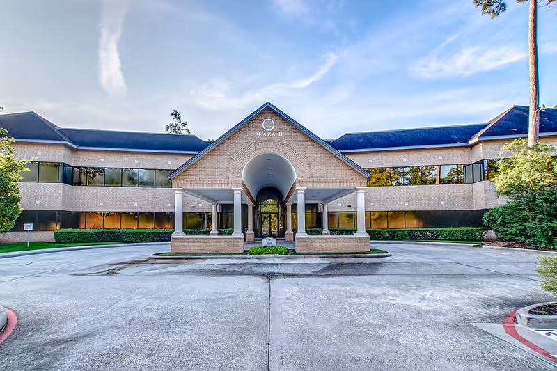 Exterior view of Comfort Keepers building entrance featuring brick archway and circular drive