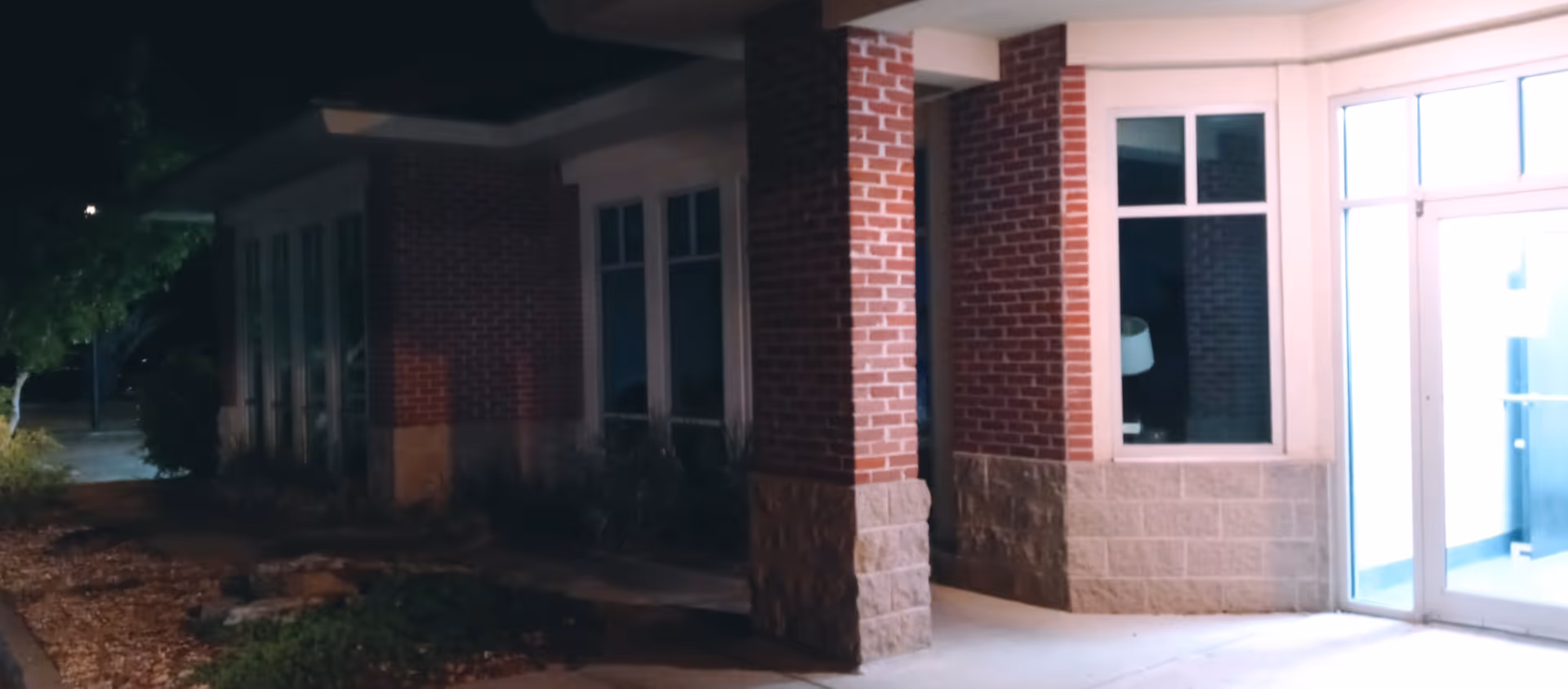Exterior view of Enhabit Home Health facility entrance with brick columns and glass doors.