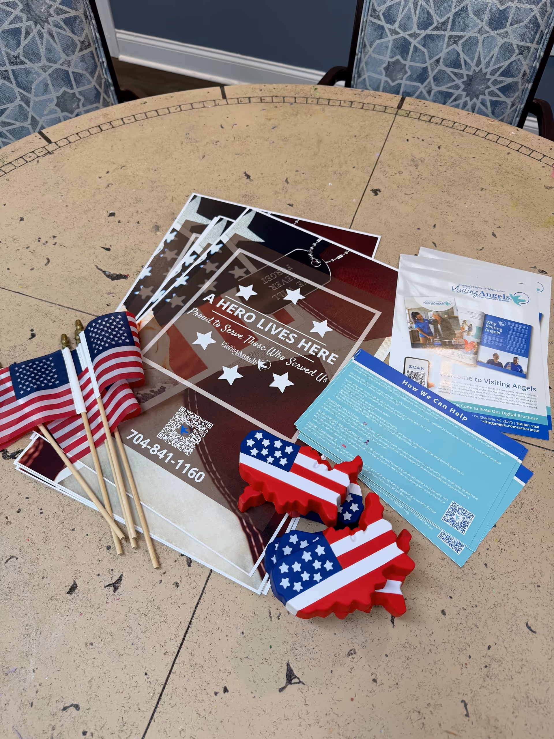 Patriotic promotional materials and American flags spread on a round outdoor table.