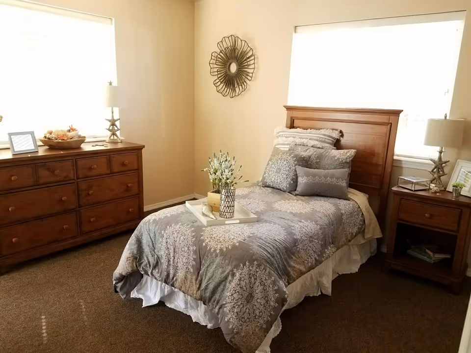 A neatly arranged bedroom with a wooden bed, dresser, and matching nightstands.
