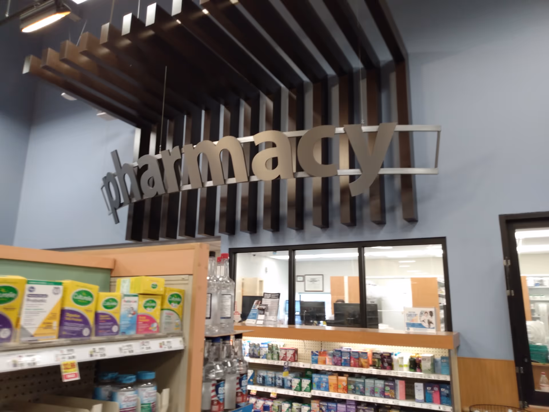 Interior of a Kroger Pharmacy with large sign and shelves of products.