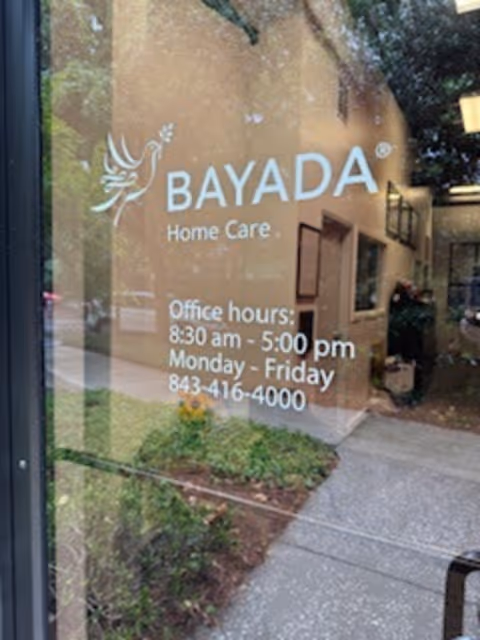 Glass door displays BAYADA Home Care sign with office hours and phone number.