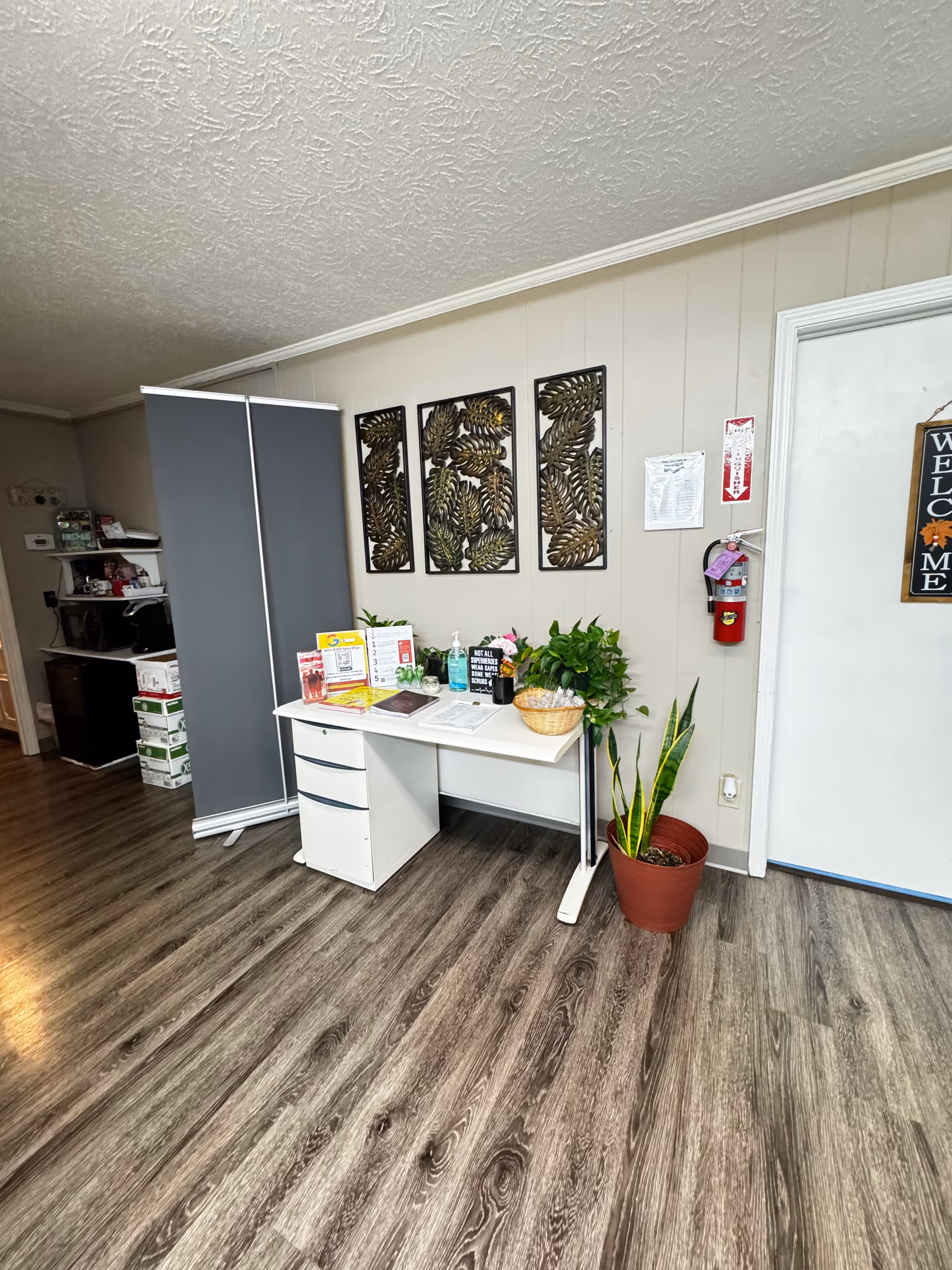 Reception desk with brochures, plants, and wall art in a senior living facility.
