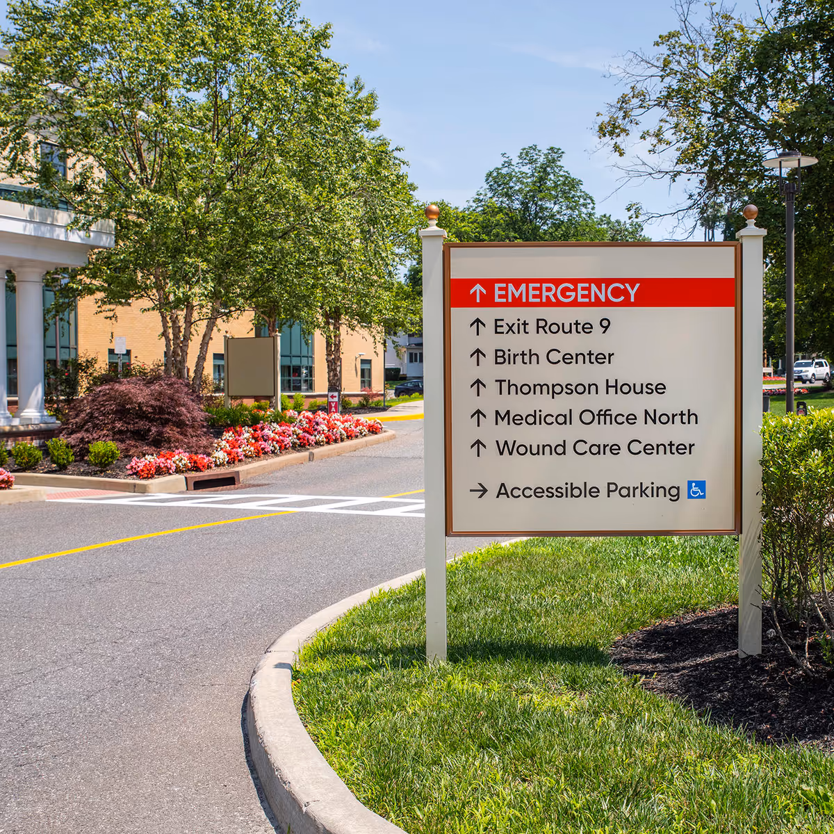 Exterior view of a medical facility with an emergency sign and landscaped grounds