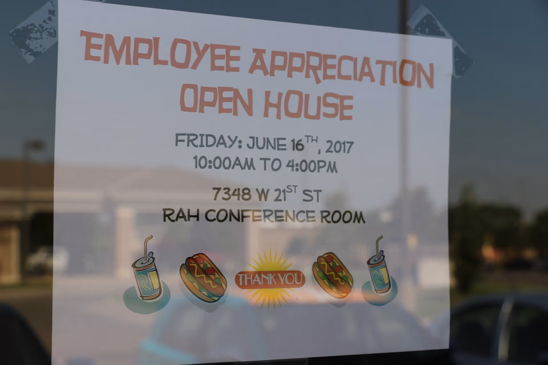 Poster on glass window advertising Right at Home employee appreciation open house event.