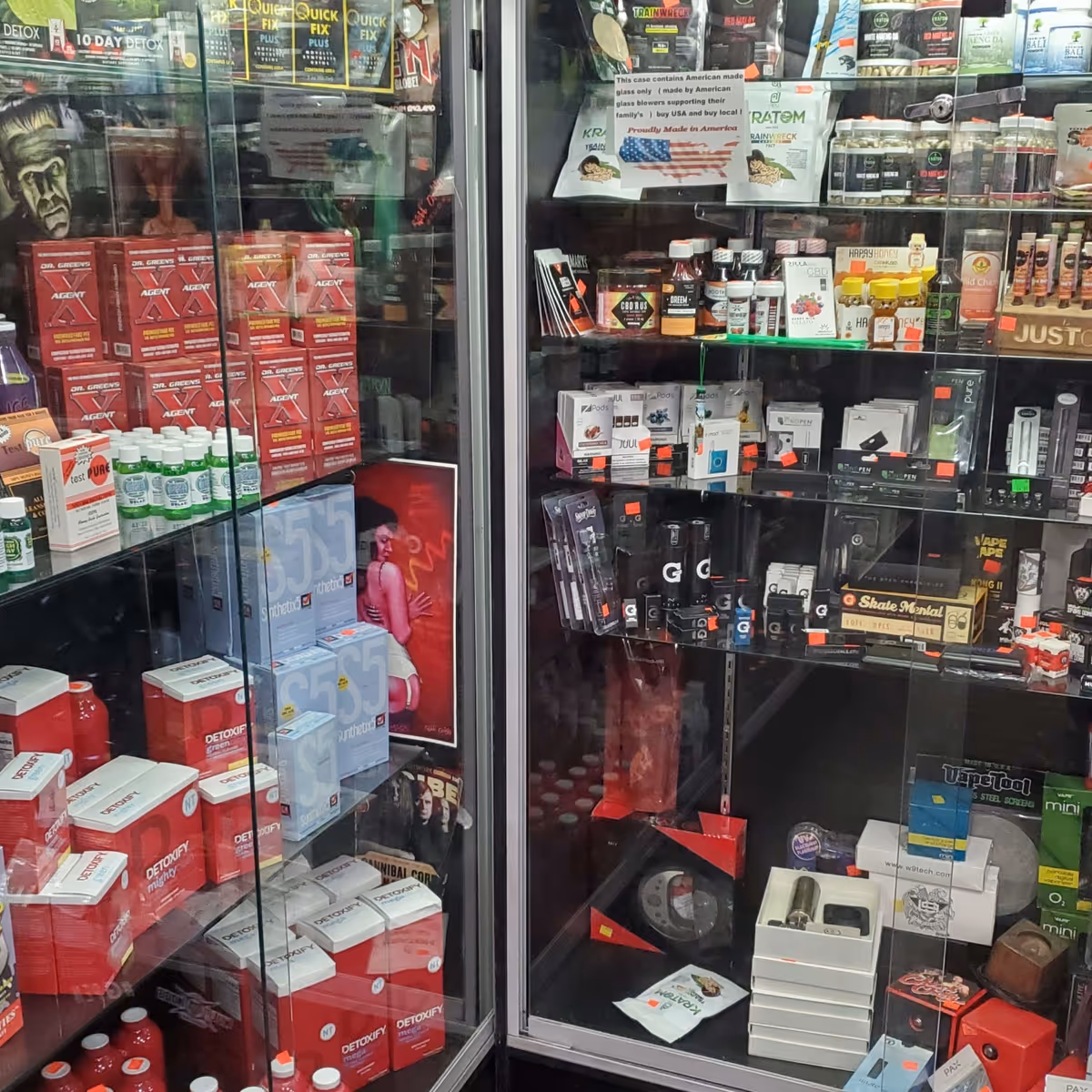 Glass display cases filled with assorted pills, bottles, and vaping devices.
