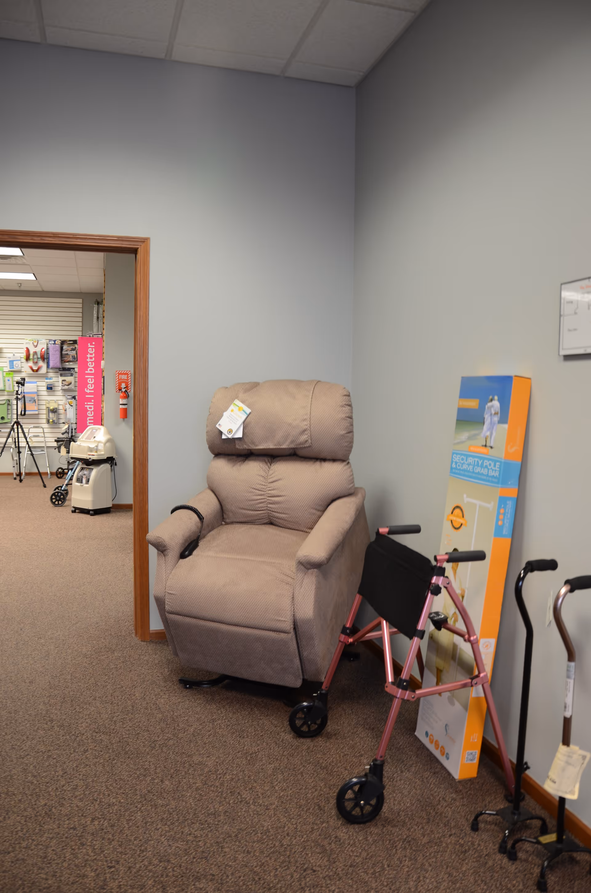 Beige recliner chair and pink walker in a quiet senior care facility corridor.