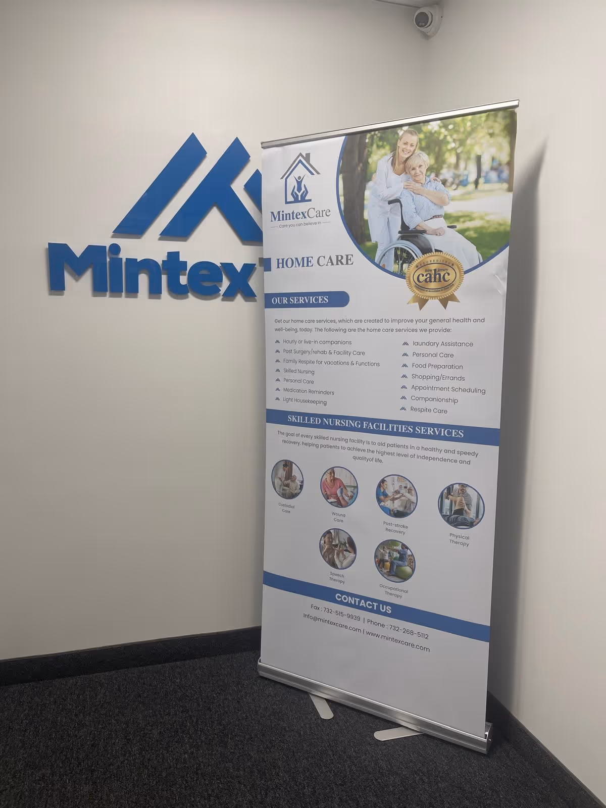 Indoor lobby corner with MintexCare sign on wall and a roll-up service banner.