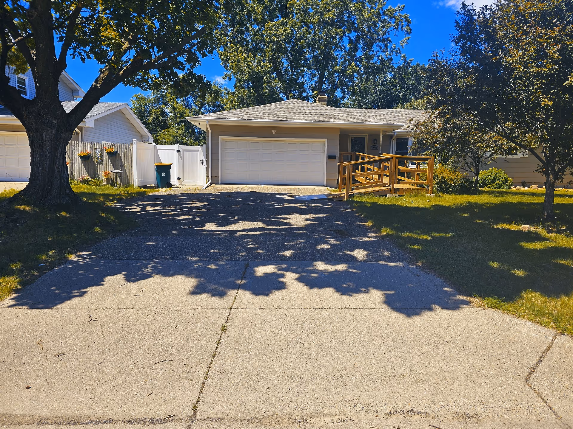 Exterior of a senior care facility with a ramp, driveway, and trees.