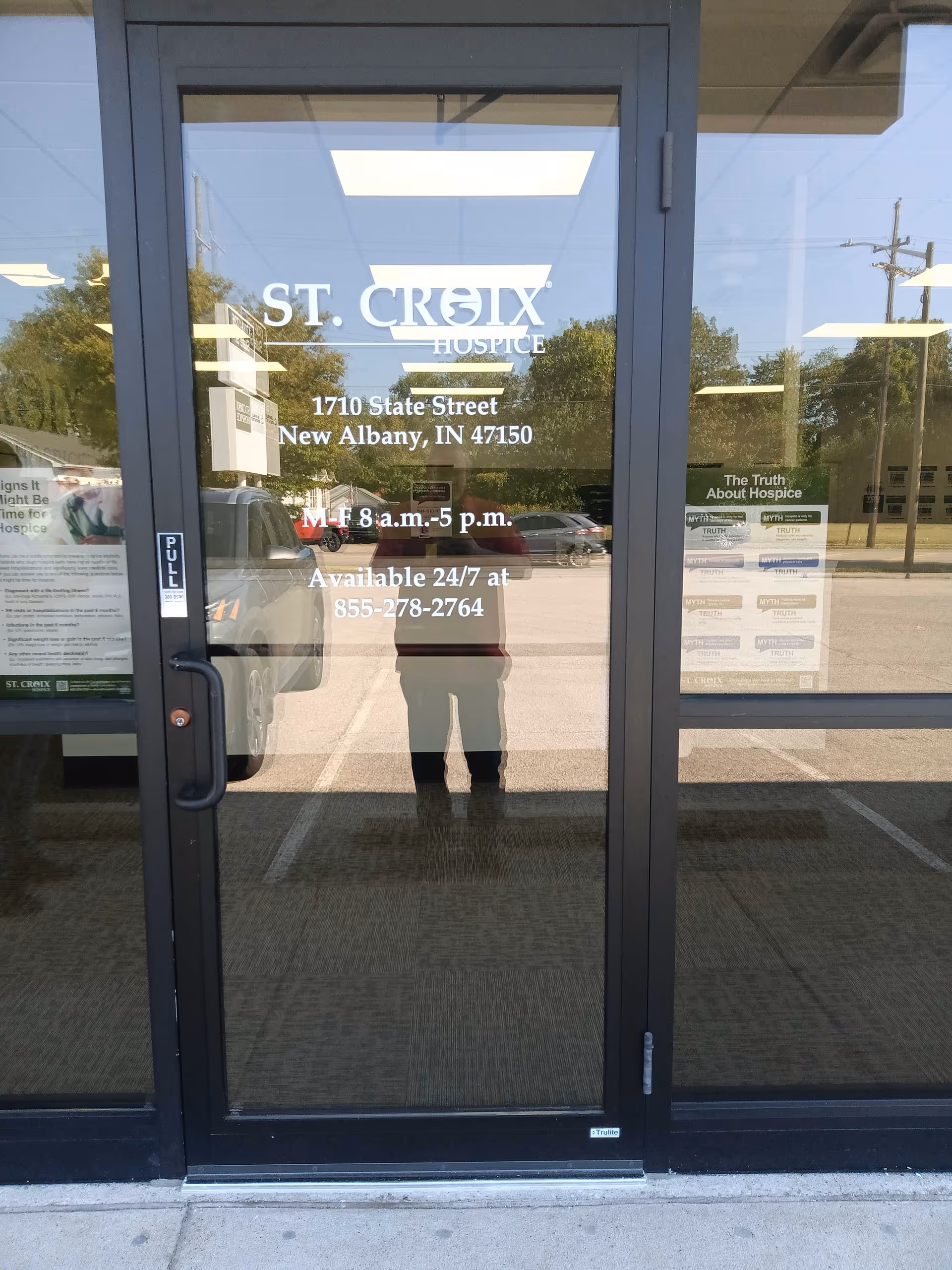 Glass entrance doors at St. Croix Hospice with reflected parking lot.