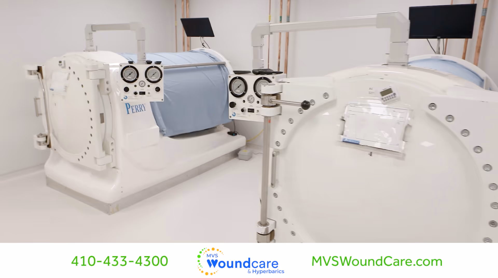 Two white hyperbaric chambers in a sterile medical room with control panels.