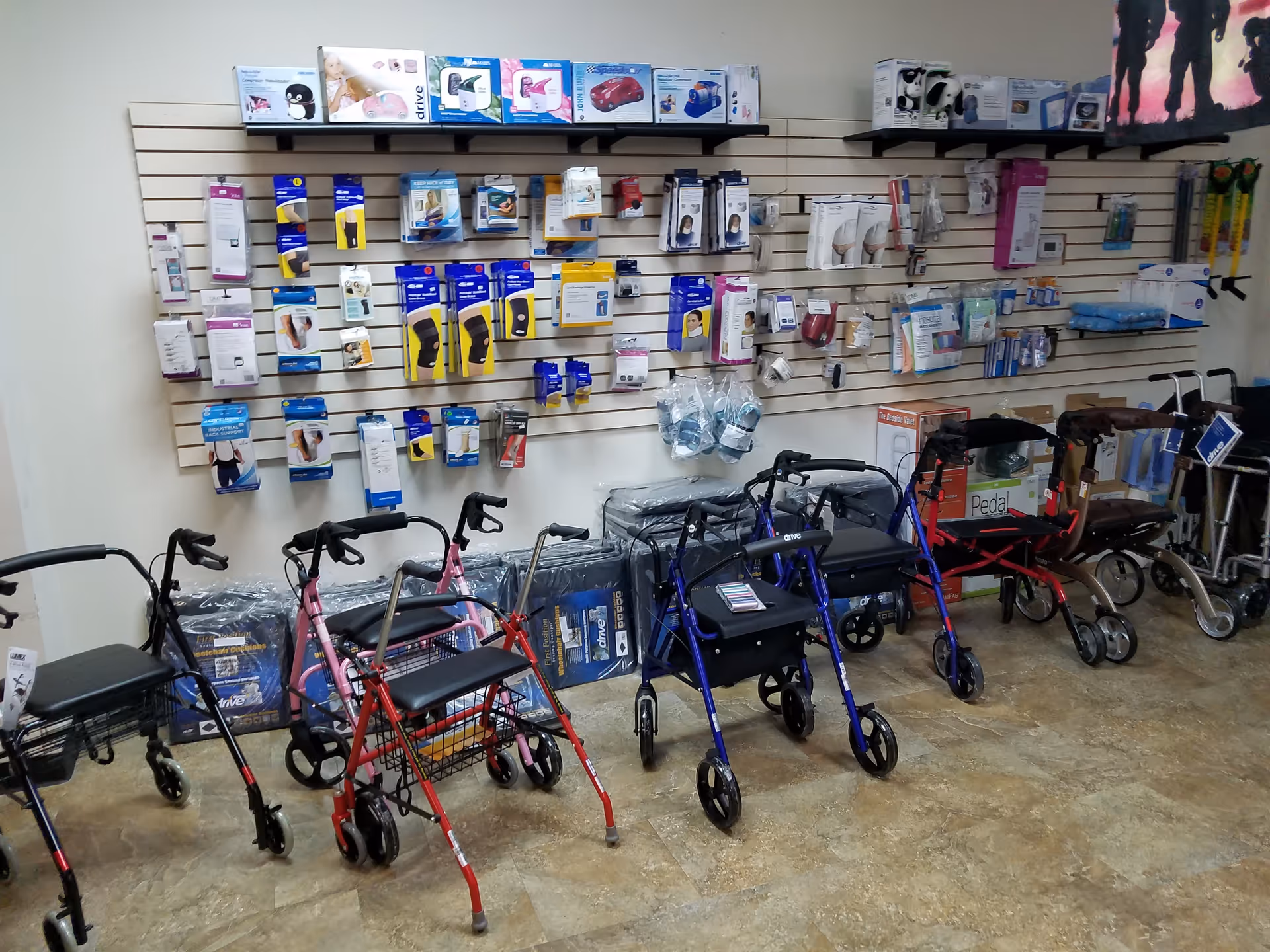 Indoor showroom with walkers and mobility aids displayed along a wall.