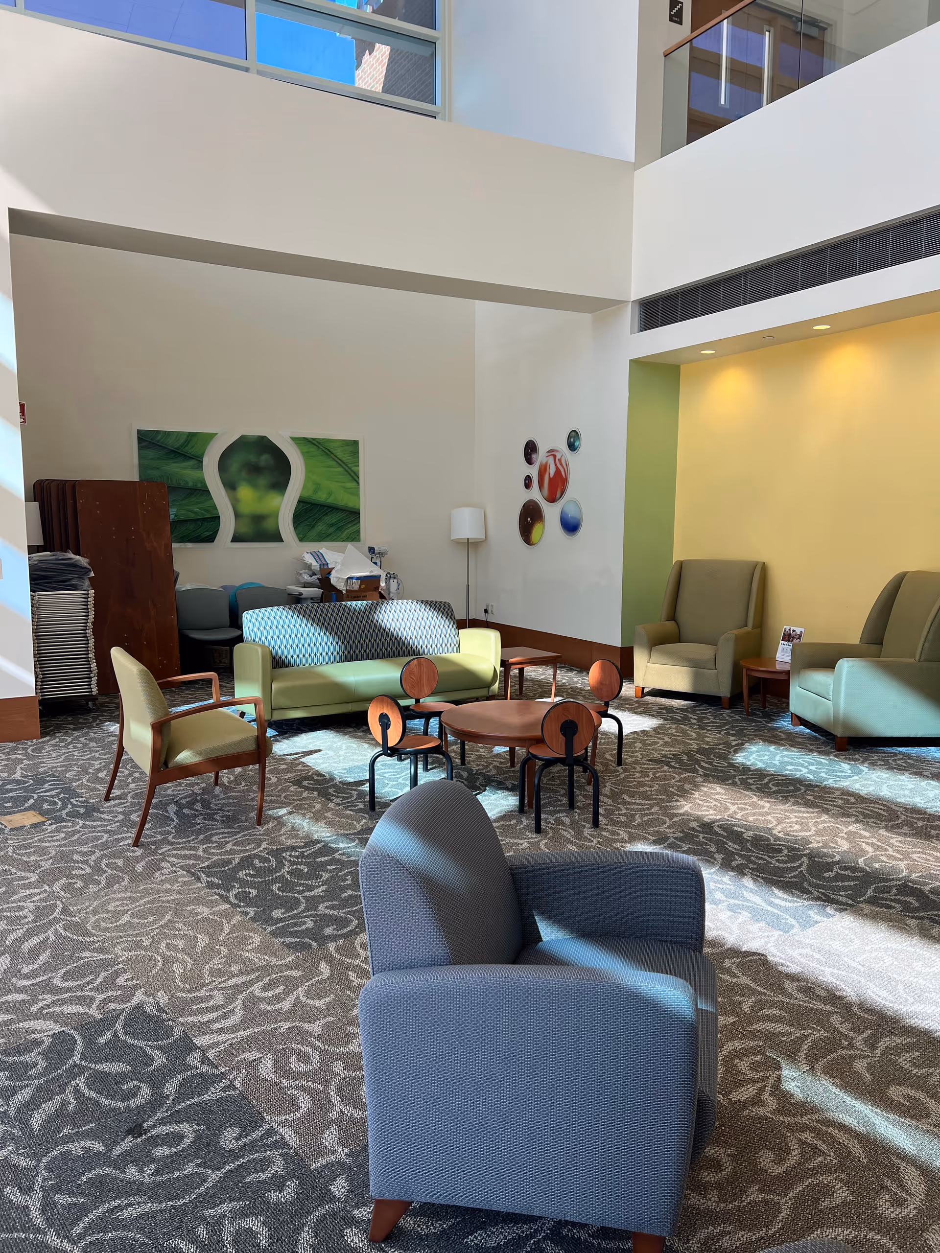 Bright modern senior living lobby with assorted chairs, sofas, and circular coffee tables.