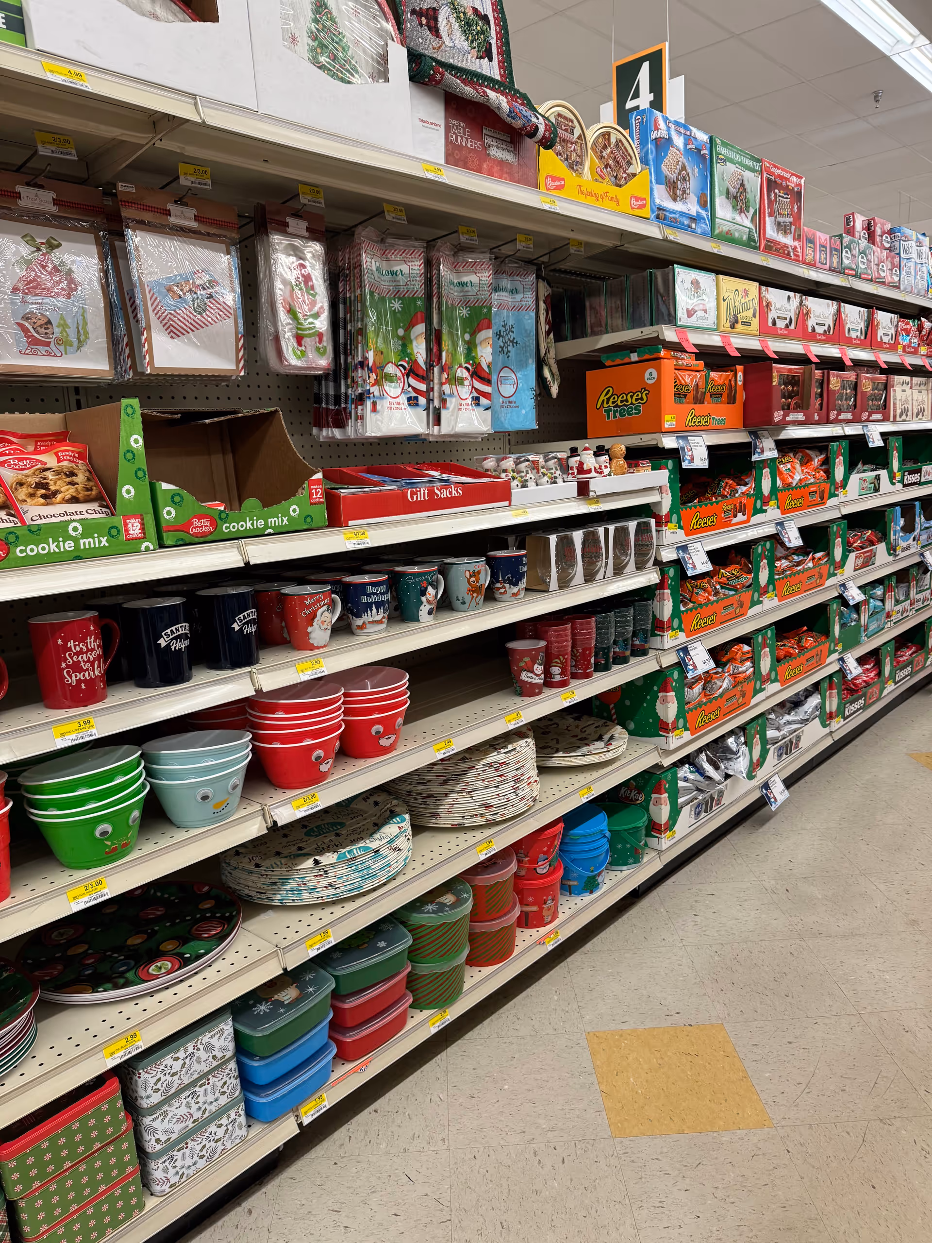 Aisle of holiday-themed plates, cups, and bowls on store shelves inside Discount Drug Mart
