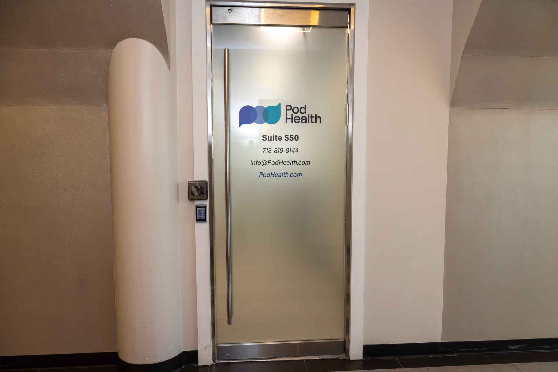 Frosted glass door labeled Pod Health Suite 550 in a hallway.
