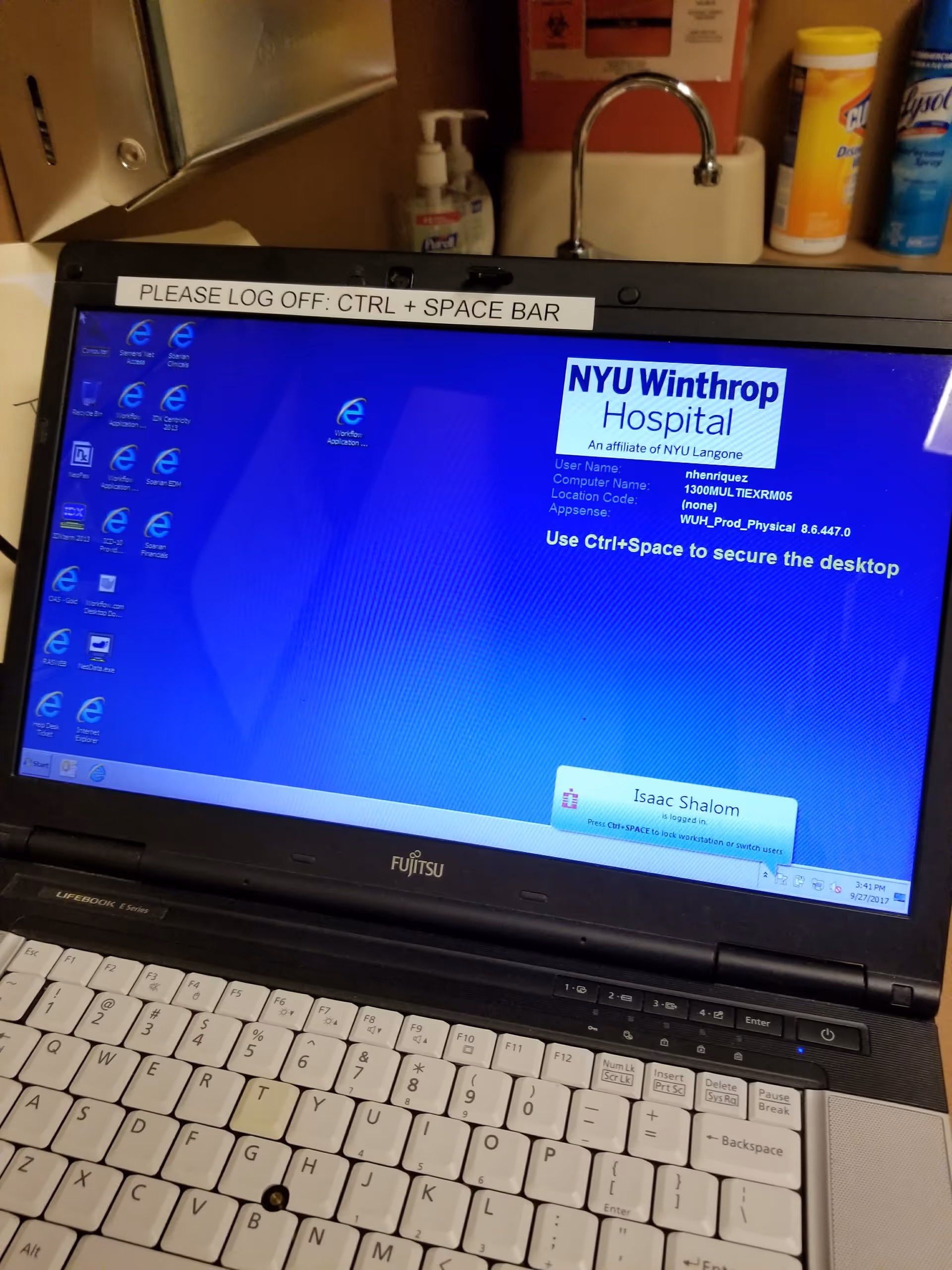 Open laptop shows NYU Langone Hospital login screen on a desk in a clinical interior.