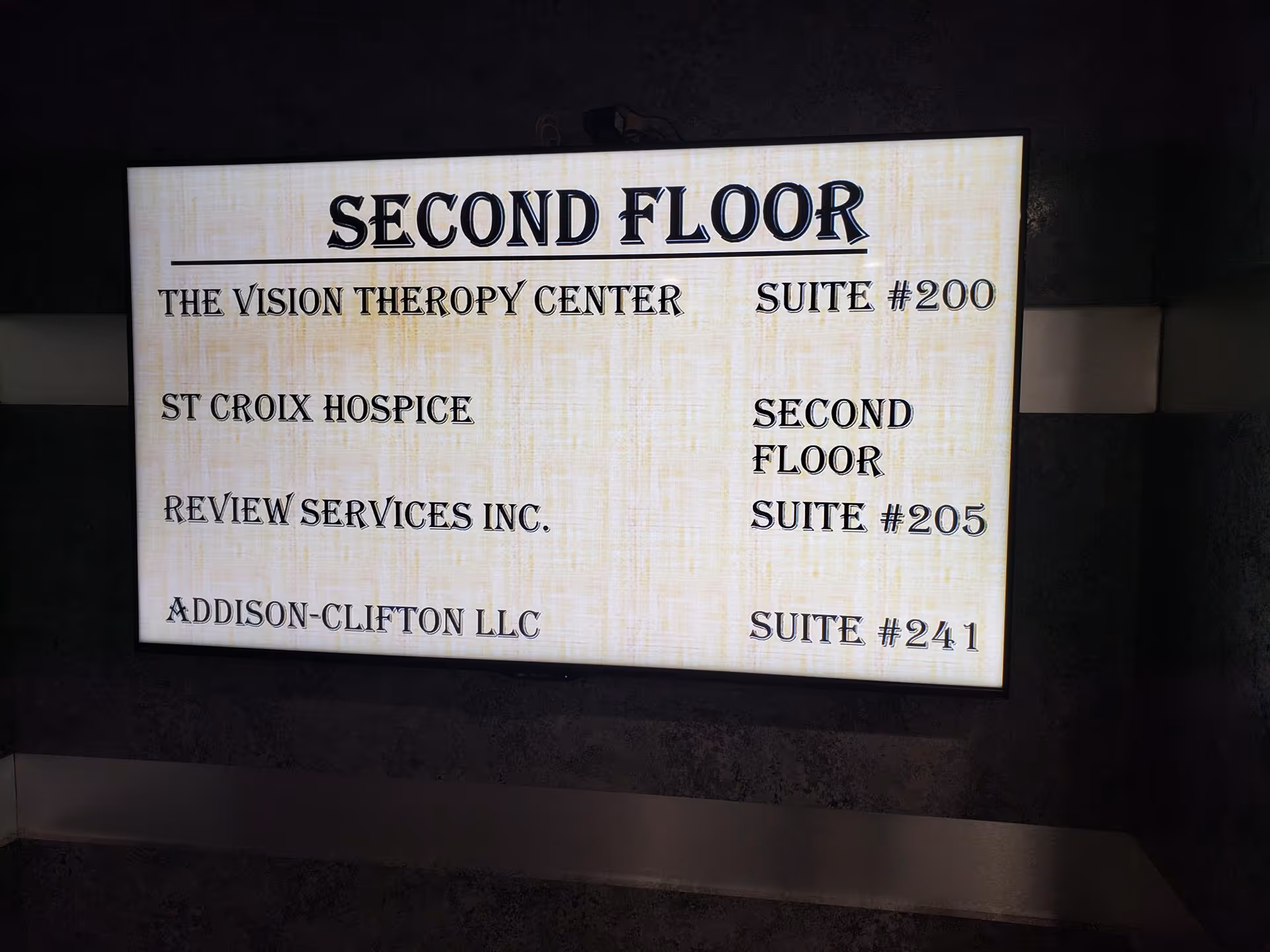 Backlit wall sign listing Second Floor offices and suites in a hallway.