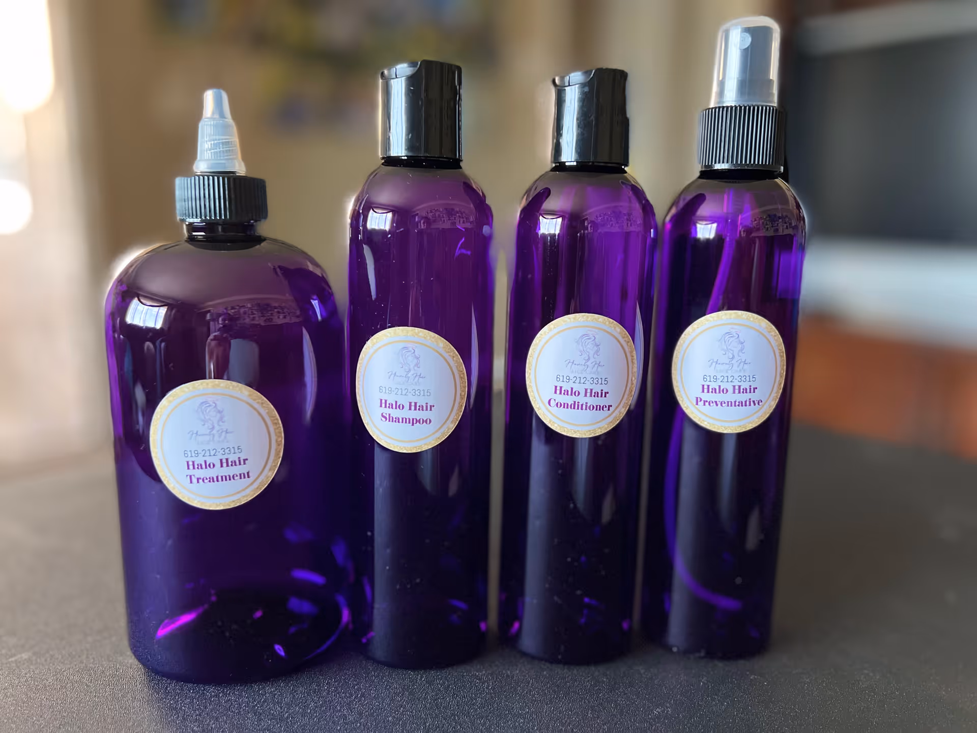 Four purple Halo Hair bottles sit on a countertop in a salon.