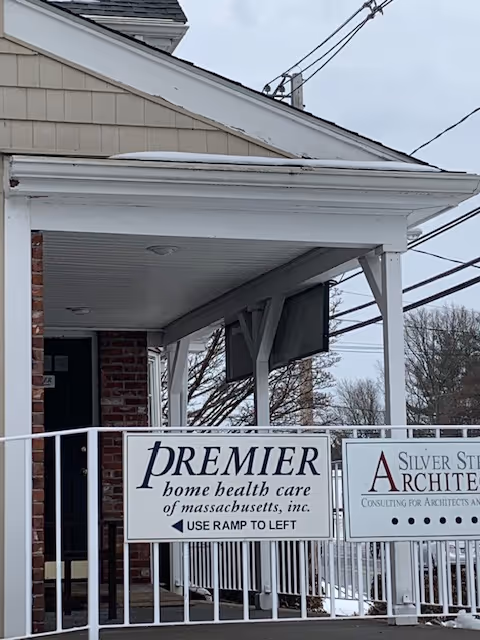 Exterior view of Premier Home Health Care Services building with signs on the railing.