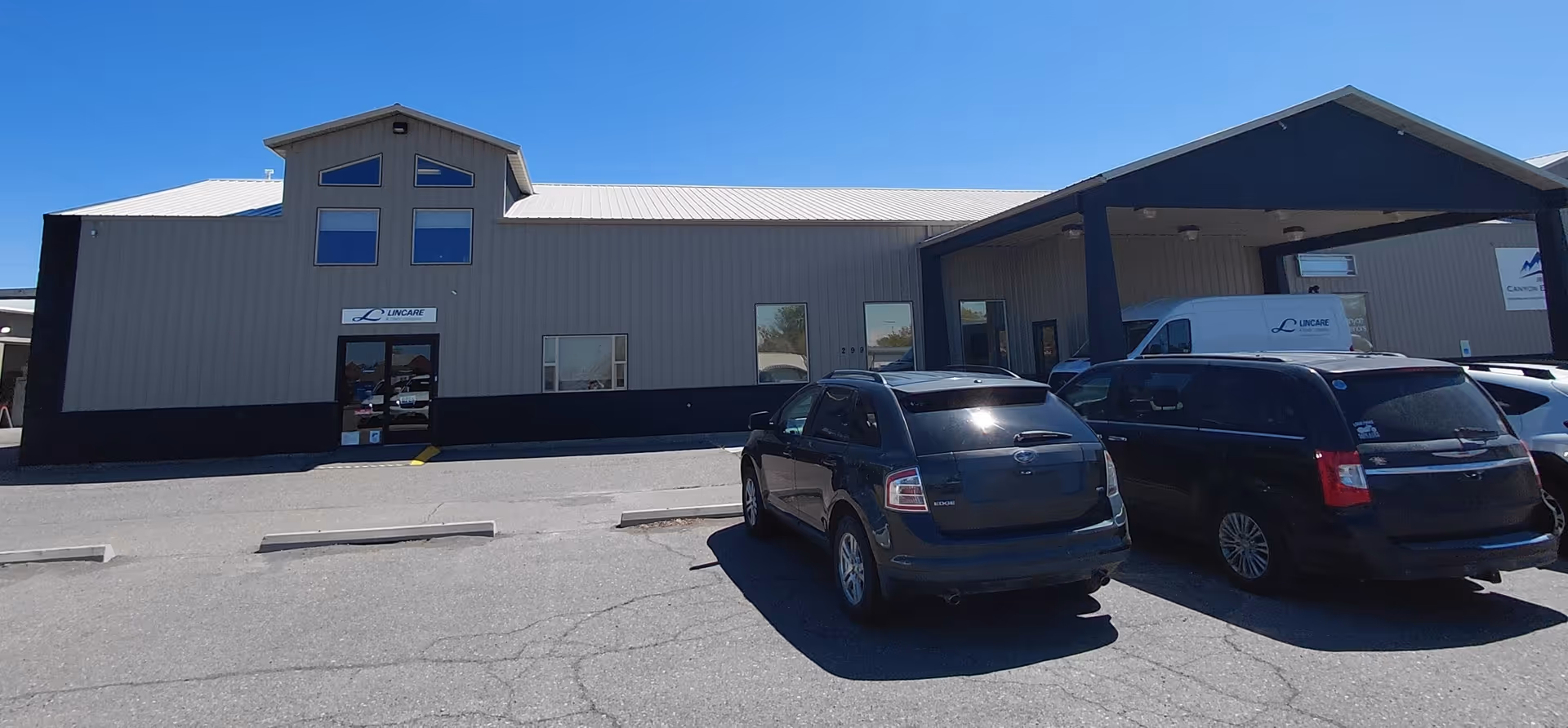 Exterior view of a LINCARE facility with a parking lot and entrance.