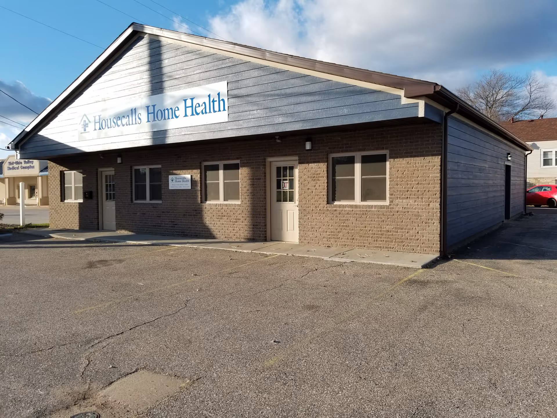 Single-story brick building with a Housecalls Home Health sign and a paved parking lot.