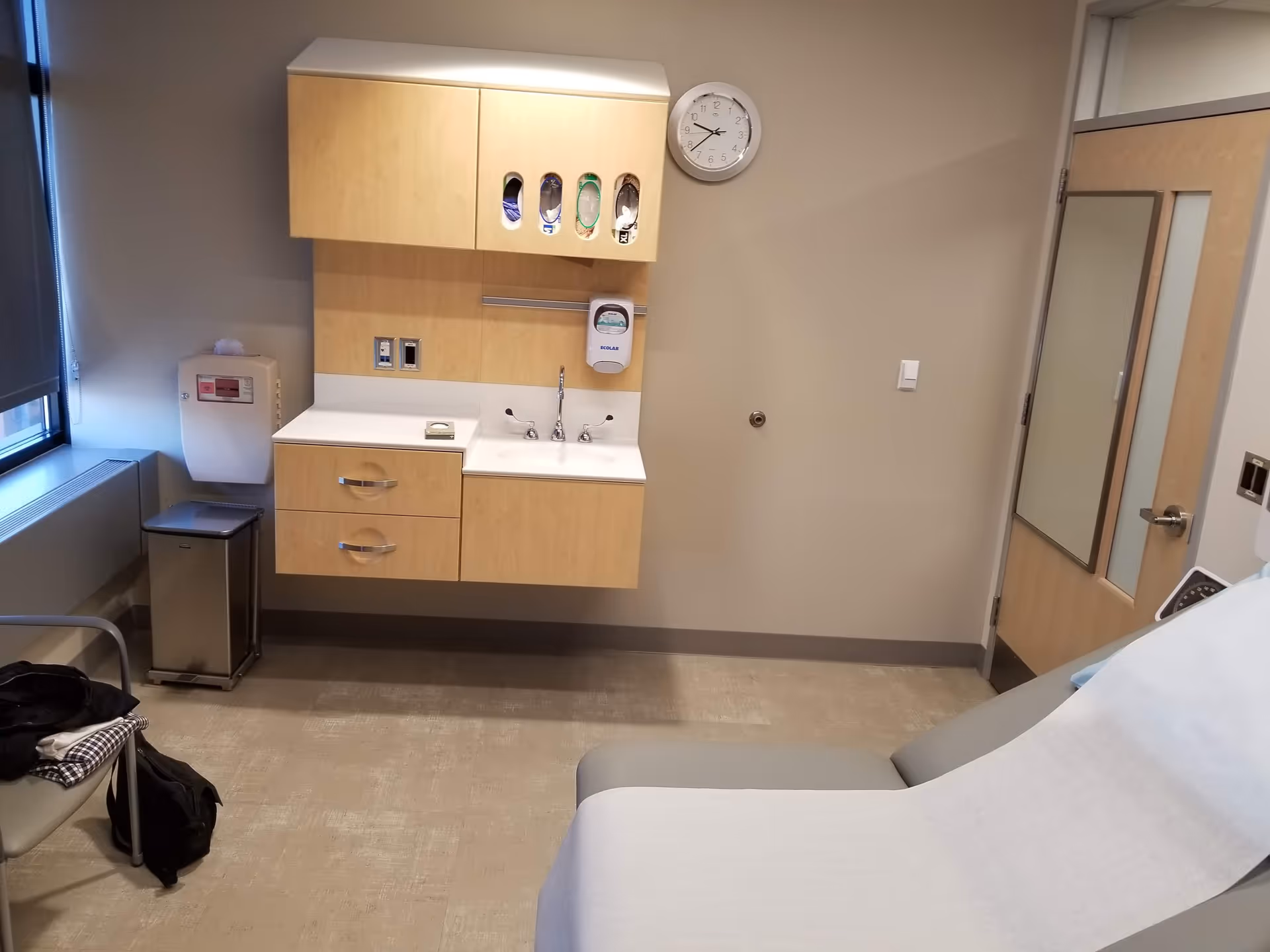 A medical examination room with a sink, cabinets, and patient bed in Johns Hopkins Outpatient Center.