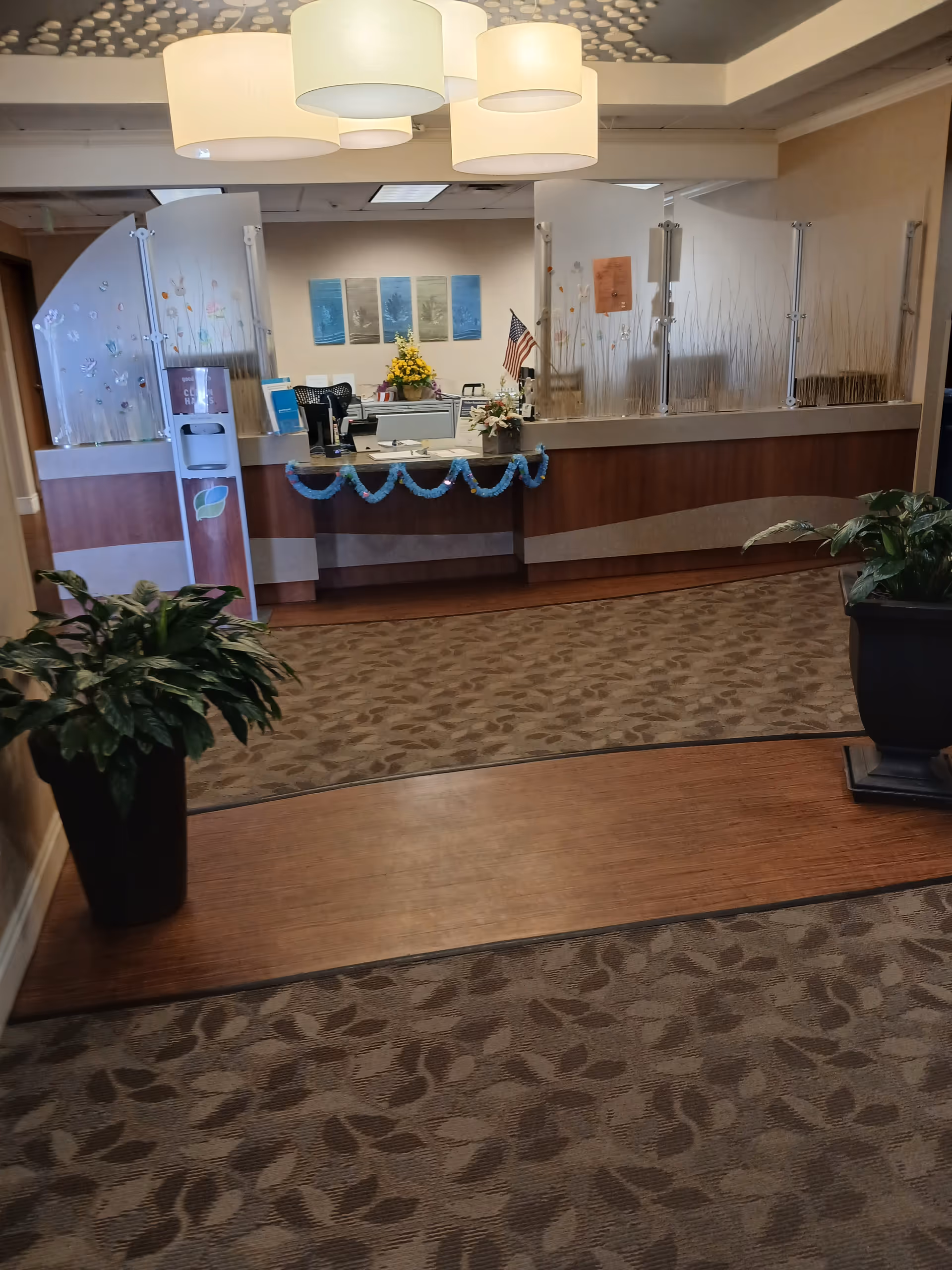 Reception desk with frosted glass dividers in a hospice lobby.