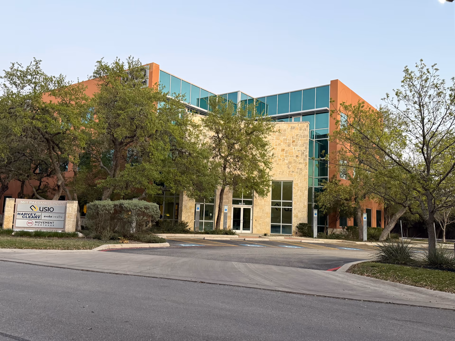 Exterior view of a modern senior care facility with glass windows and trees.