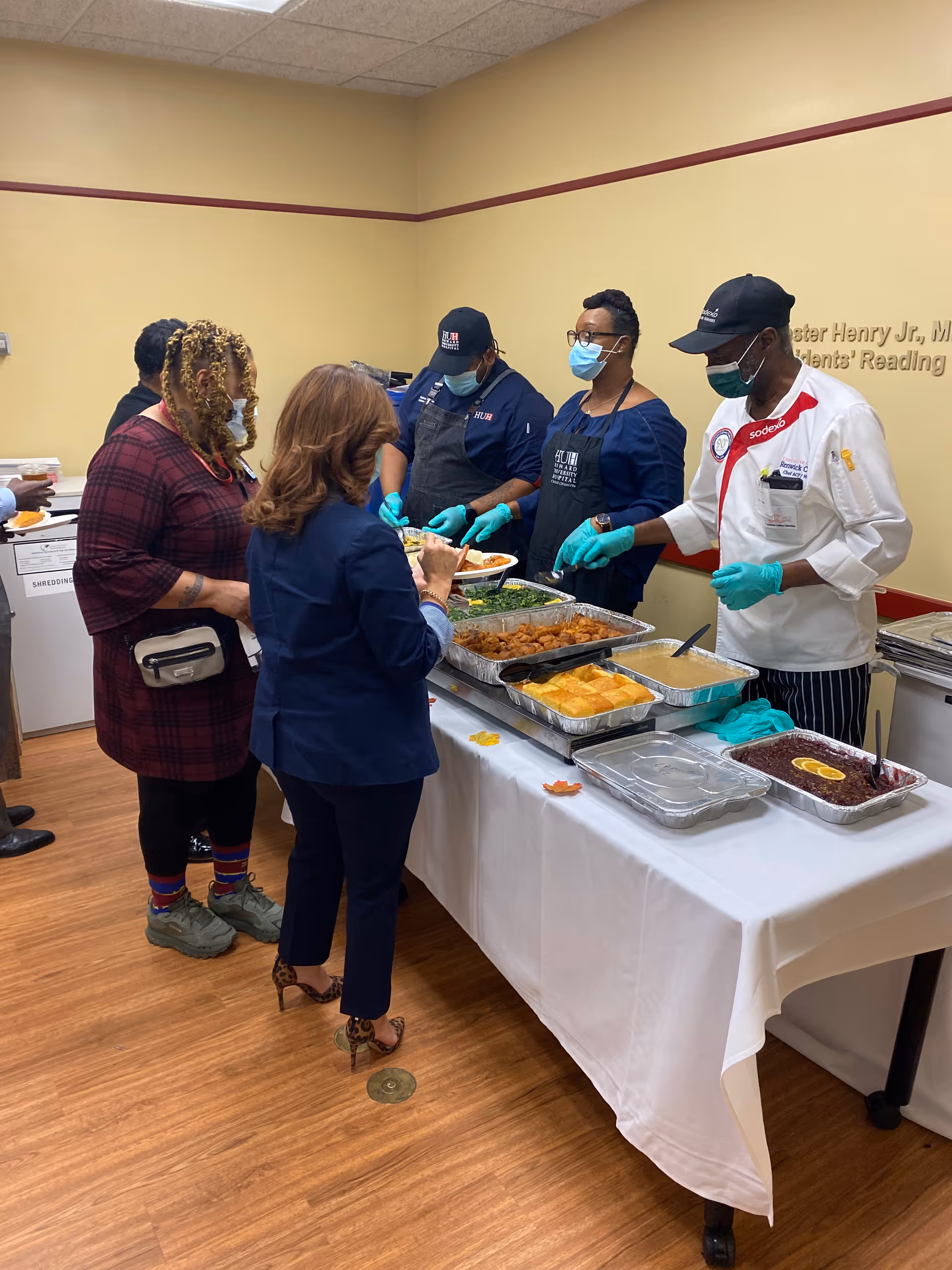 Buffet-style meal served to residents by staff in a dining room.