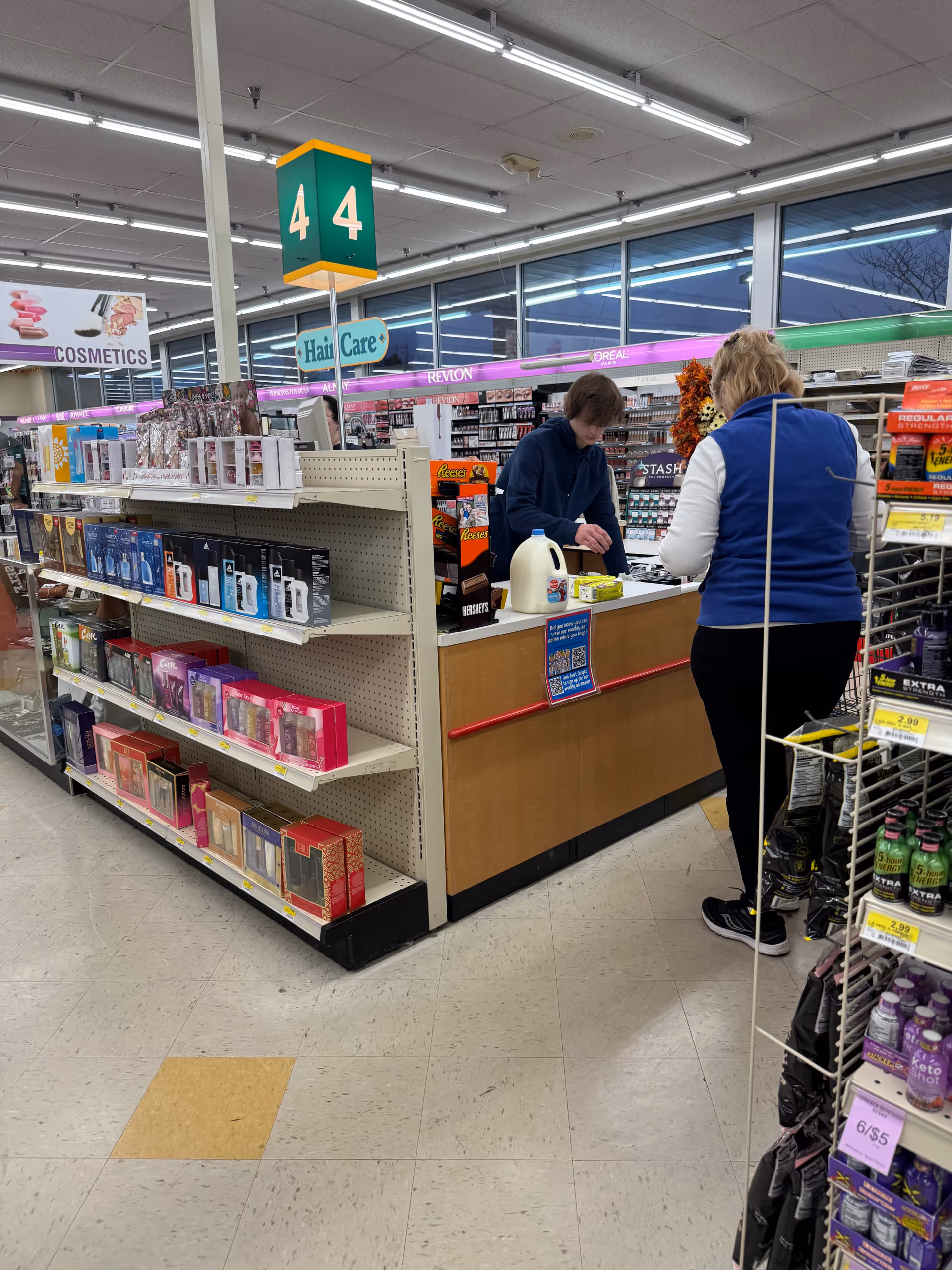 Inside Discount Drug Mart pharmacy, a checkout counter with a customer and attendant.