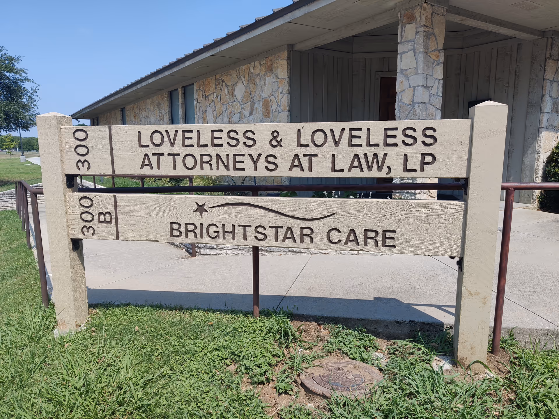 BrightStar Care sign on a stone building exterior with a grassy lawn.