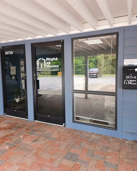 Entrance to Right at Home facility with glass door and window under a covered walkway.