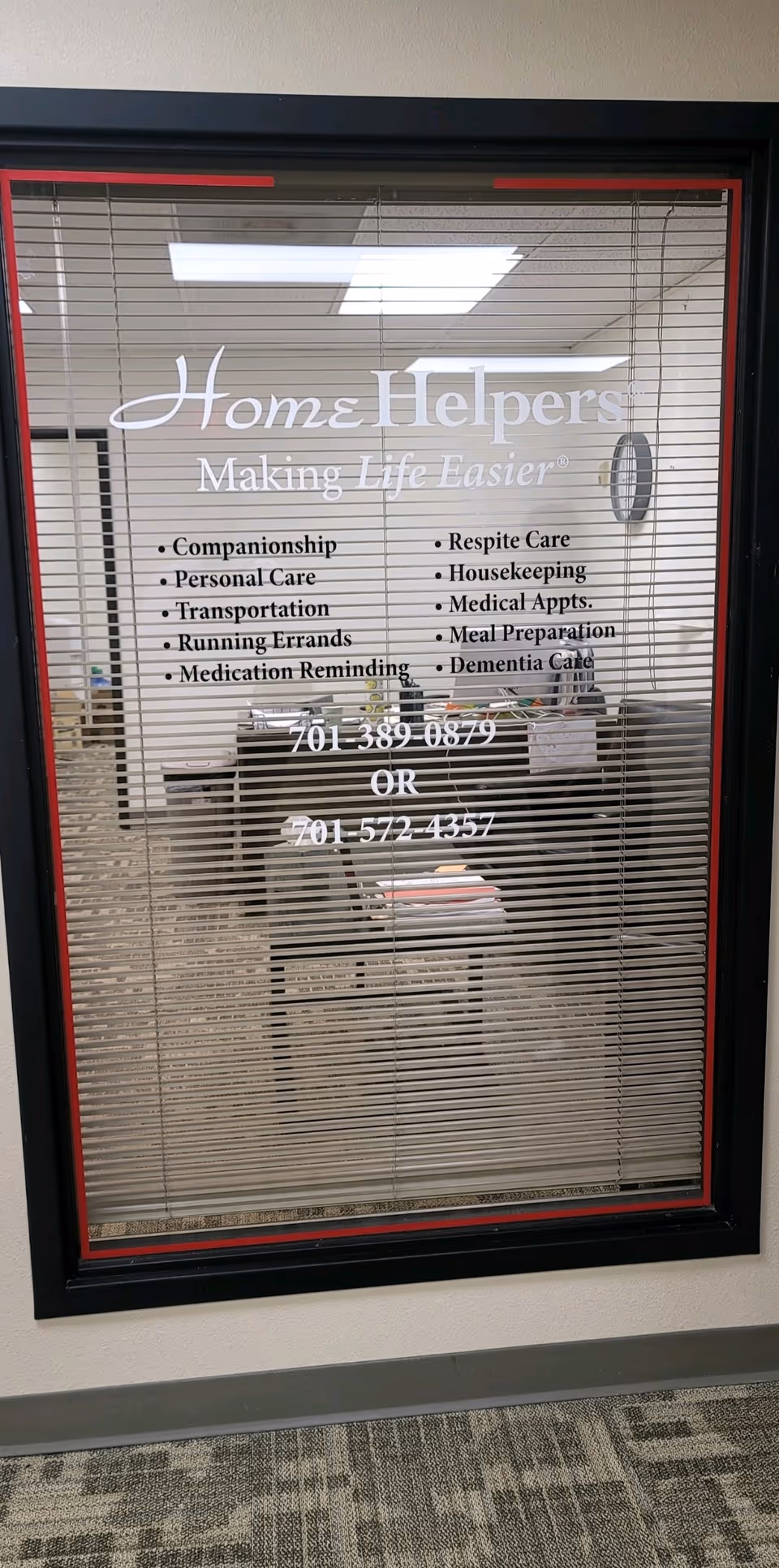 Framed glass door with blinds displaying Home Helpers branding and service list inside an office.