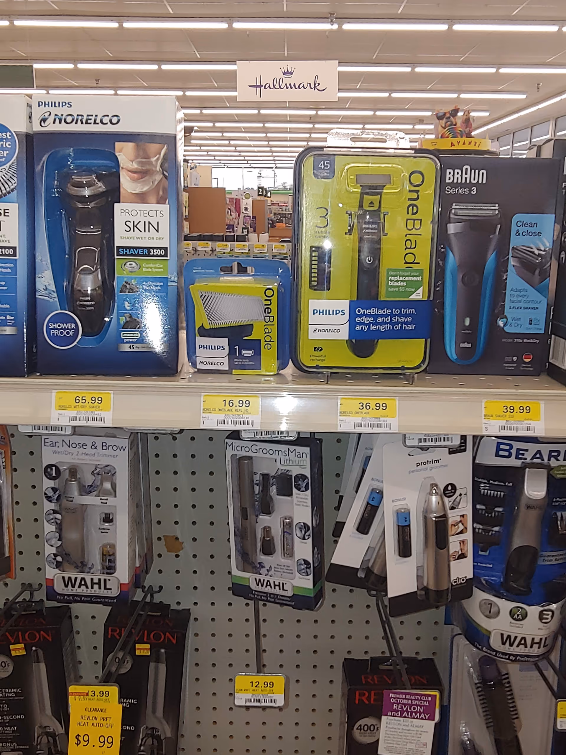 Store aisle displaying boxed razors and grooming devices on peg shelves.