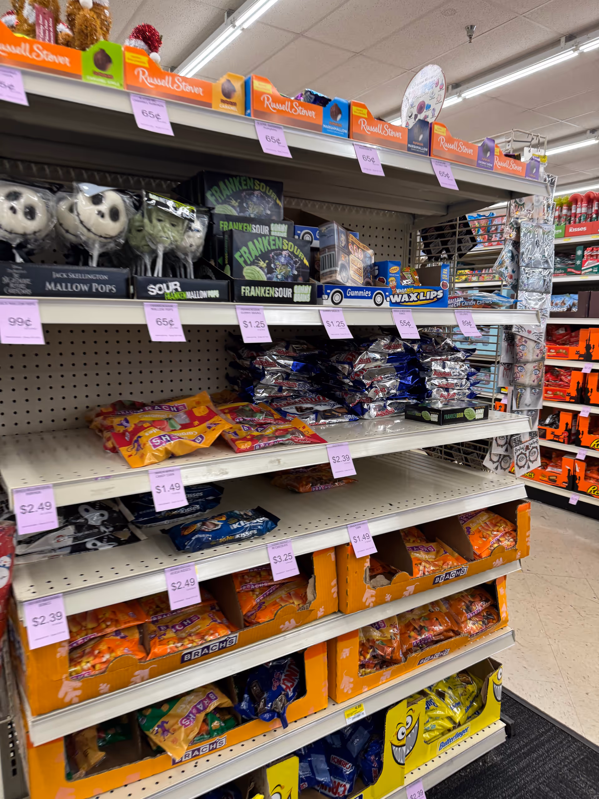 Aisle displays assorted candies and snacks on shelves inside Discount Drug Mart.