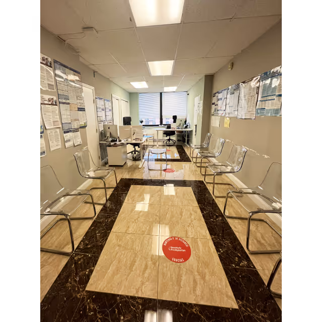 Interior waiting area of a senior care facility with rows of chairs, posters, and desks.