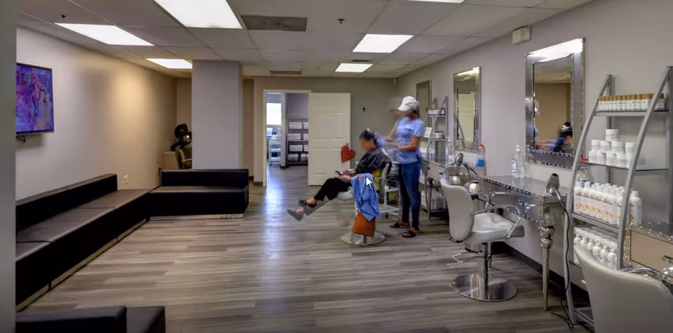 Hair salon inside a senior living facility with a stylist and resident.