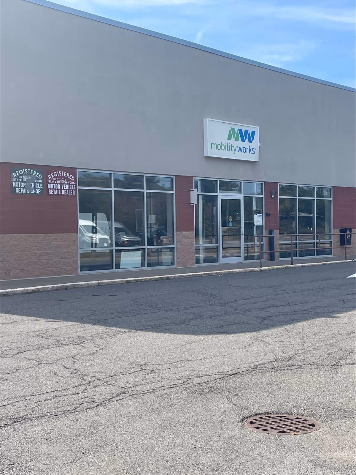 Exterior view of MobilityWorks storefront with glass doors and logo on building.