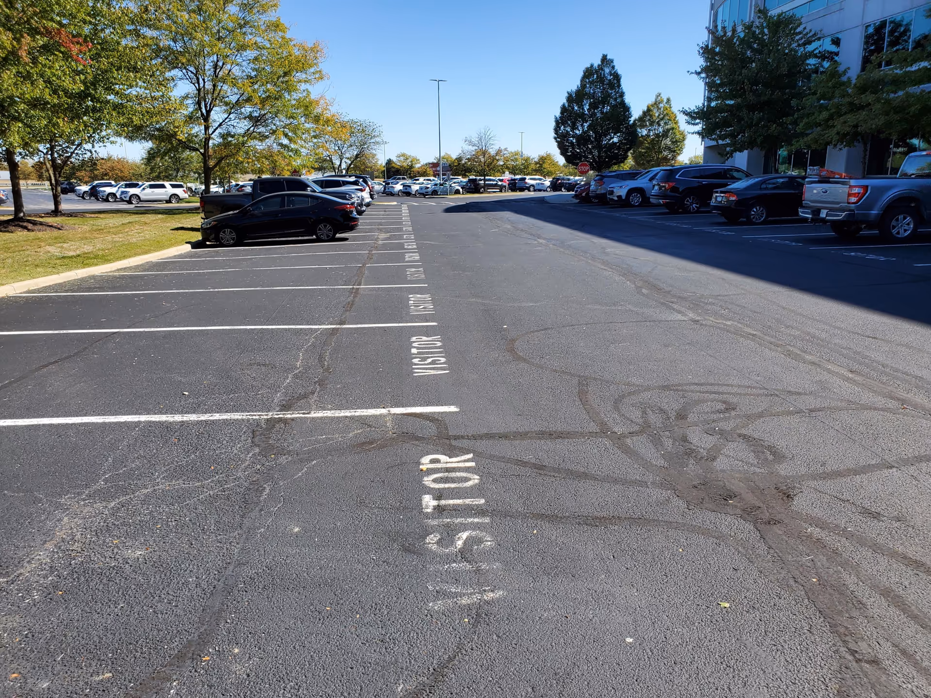 Parking lot in front of St. Croix Hospice building with cars and trees.