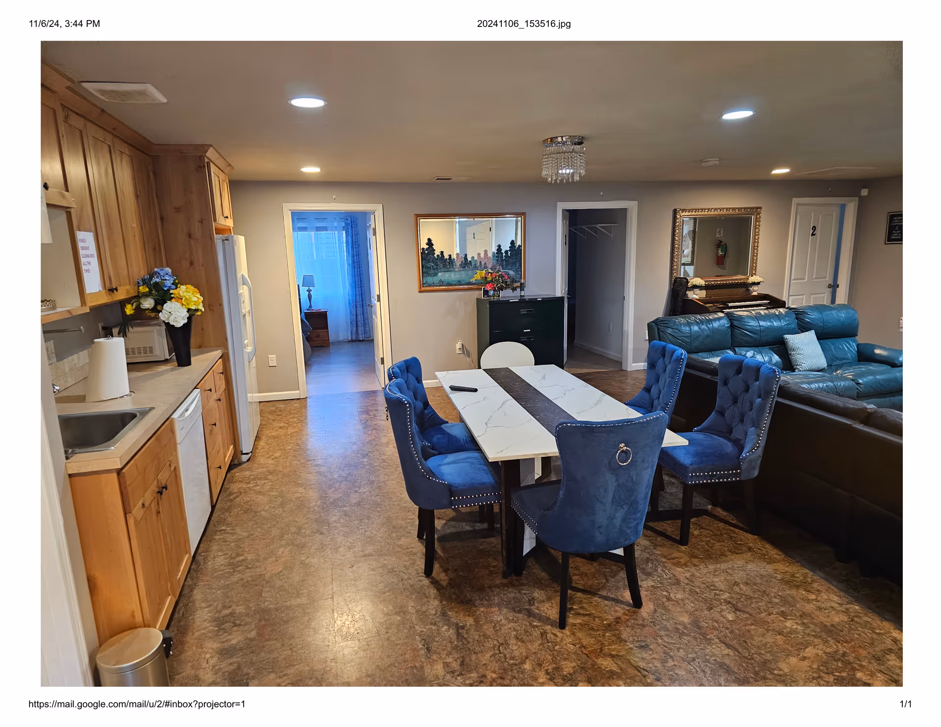 Cozy communal area with marble dining table, blue upholstered chairs, and a teal seating lounge.