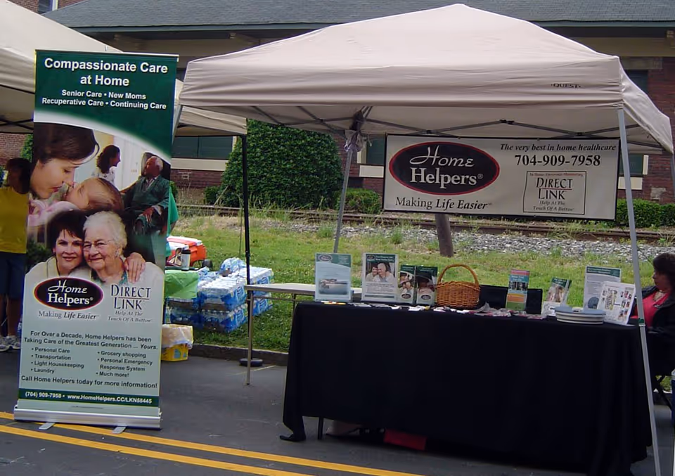Outdoor tented information booth for Home Helpers Home Care with banners and brochures.