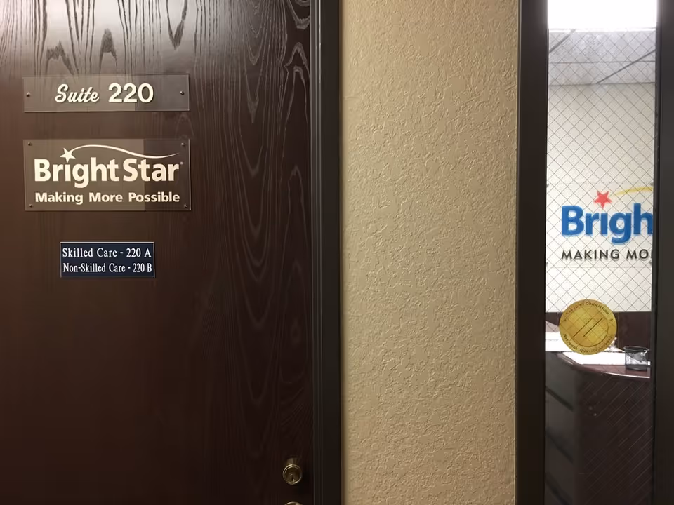 Interior hallway door with BrightStar Suite 220 sign and logo on wall.