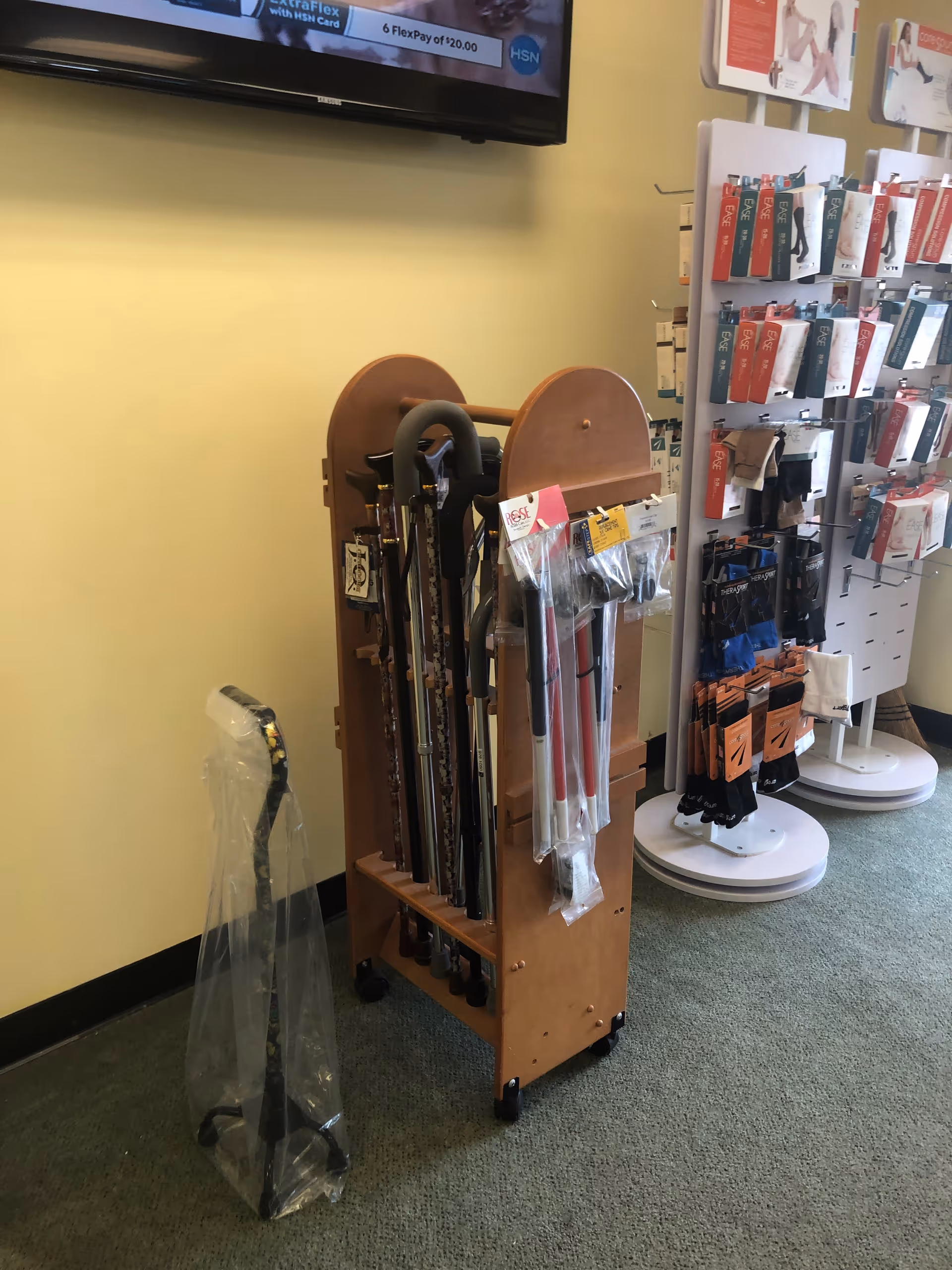 Wooden cane and umbrella rack displayed inside a yellow-walled interior.