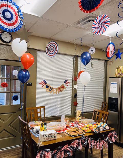 Patriotic decorations and snacks arranged on a dining table inside a BrightStar Care facility.