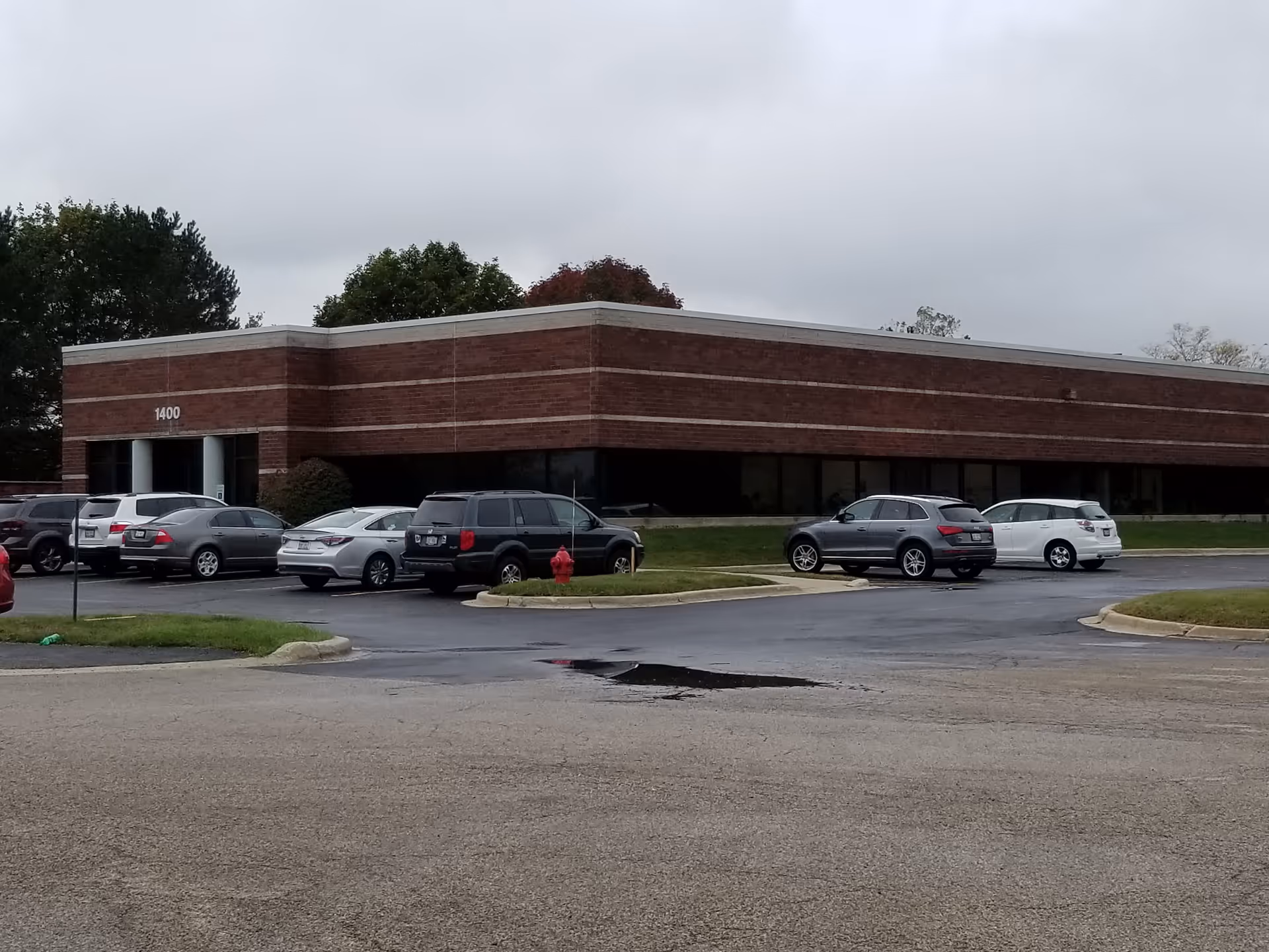Brick single-story building with a parking lot in front.